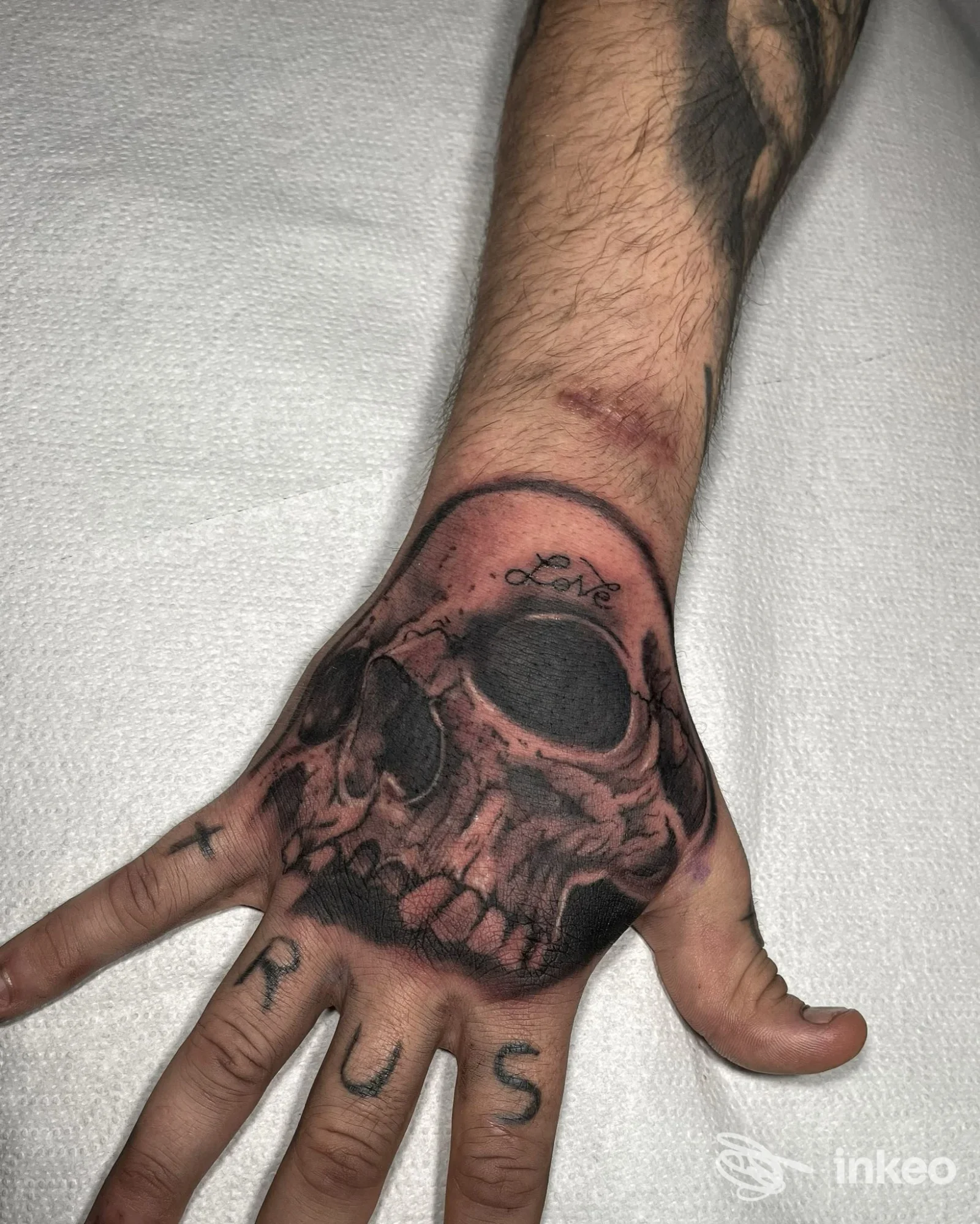 Tatuaggio realistico di teschio sul dorso della mano realizzato nello studio Orion Ink a Qualiano, con tratto scuro e sfumature su pelle.