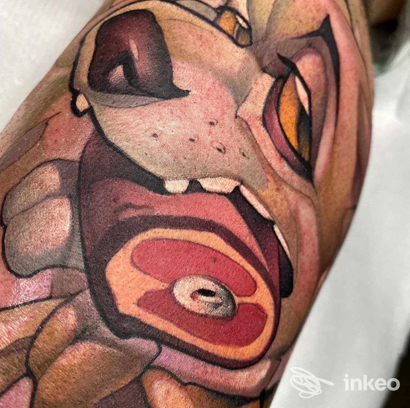 Tatuaggio sul braccio raffigurante una creatura cartoon, colori vividi e linee marcate; tatuaggio su pelle visibile sull'avambraccio, realizzato da studio Metyou Tattoo.