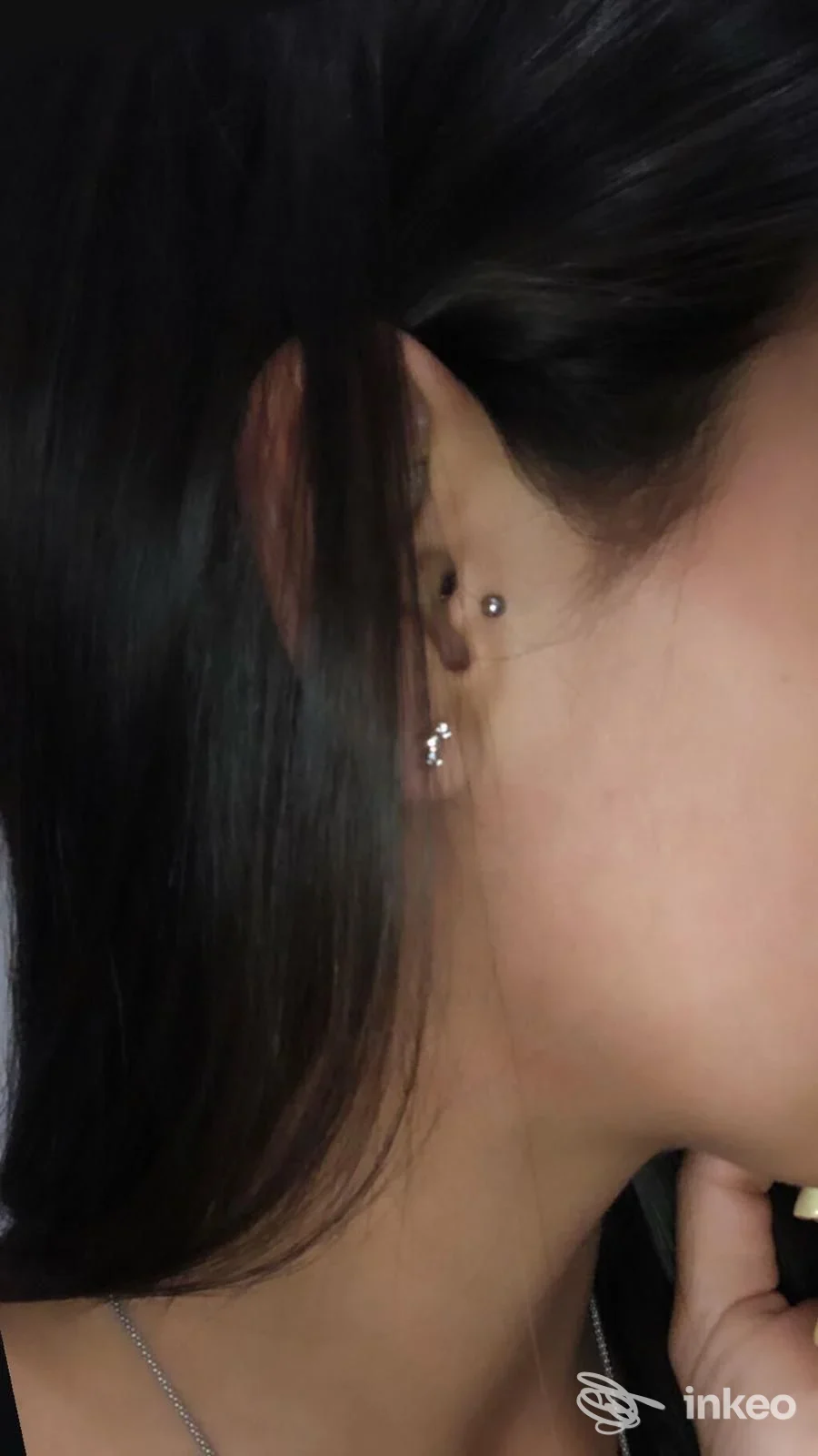 Ear piercing su orecchio con piccoli brillantini argentati, visibile da profilo; studio ORING, Napoli.