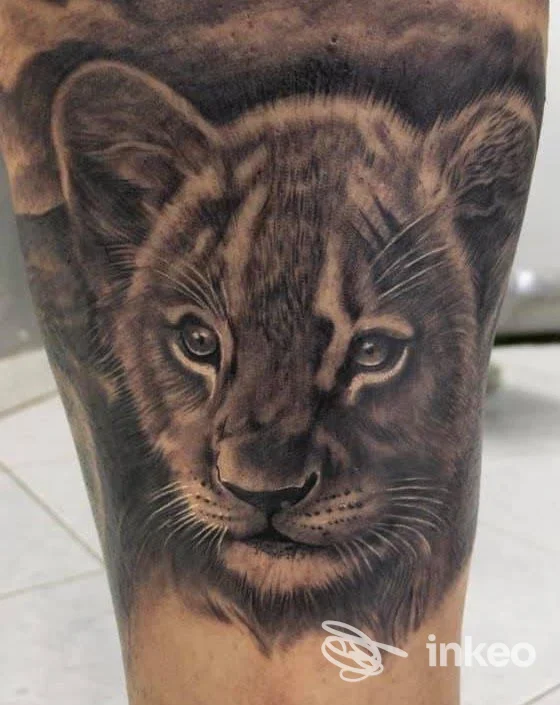 Tatuaggio realistico di leone su pelle realizzato presso Agostino Ferraiuolo Tattoo Store, Casavatore, con tonalità nere e grigie ben caratterizzate.