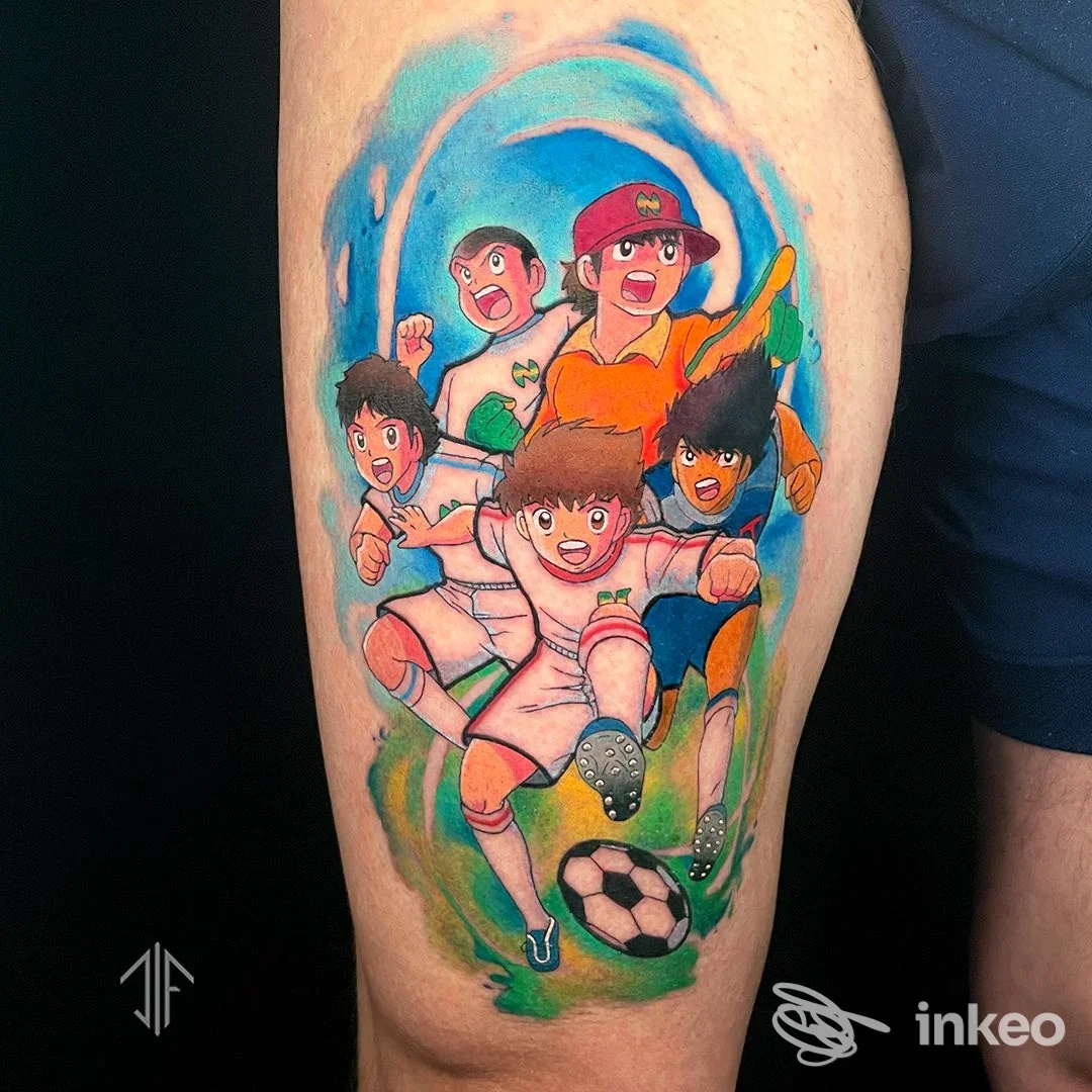 Tattoo colorato su gamba raffigurante una scena di calcio con ragazzi in stile cartone animato, colori vivaci e dinamismo.