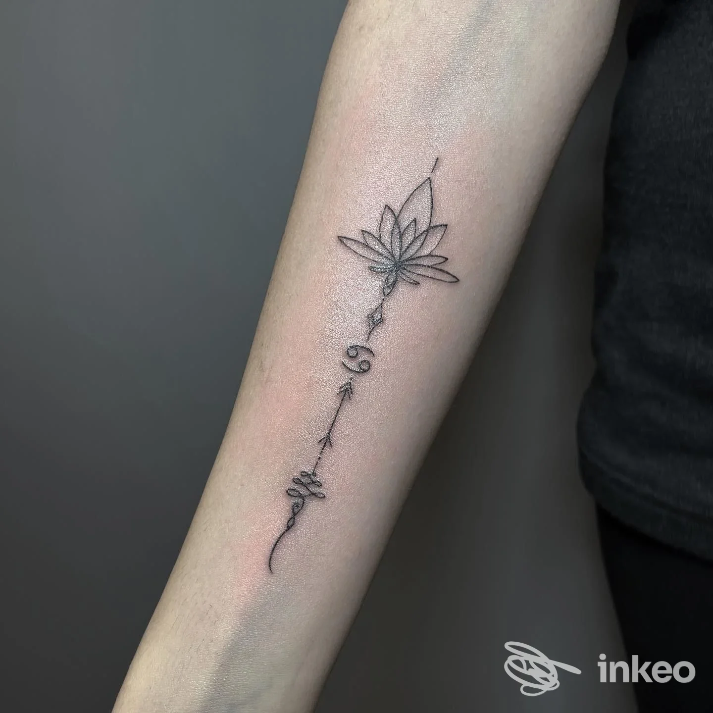 Avambraccio con tatuaggio nero raffigurante un fiore stilizzato lungo un gambo sottile; stile semplice e lineare. Studio Tripsed Tattoo & Lab, Avellino.