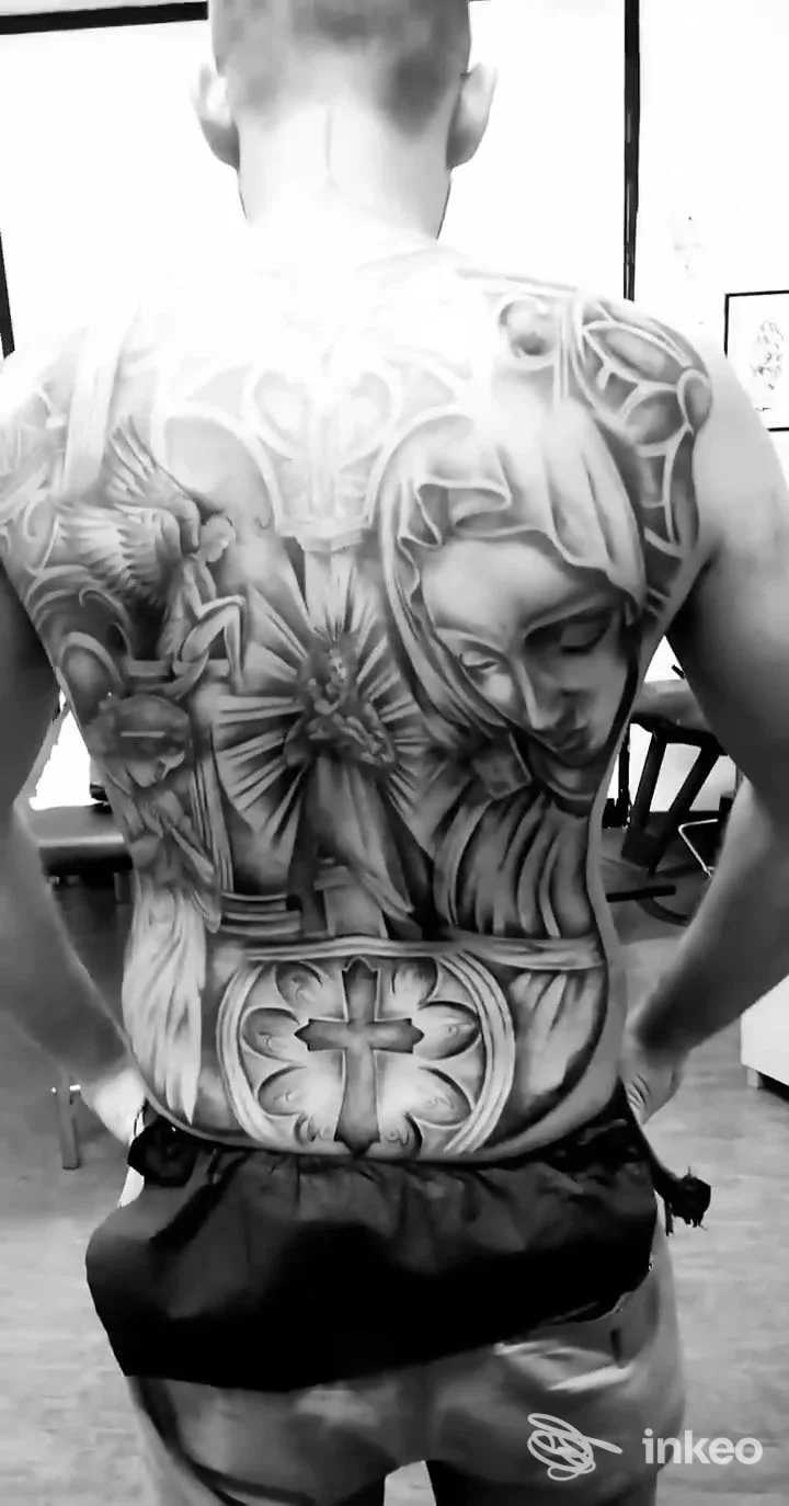 Dietro una persona senza viso mostra un grande tatuaggio completo sul dorso, con figure e simboli intricati in bianco e nero, studio Jo' Art Tattoo, Solofra.