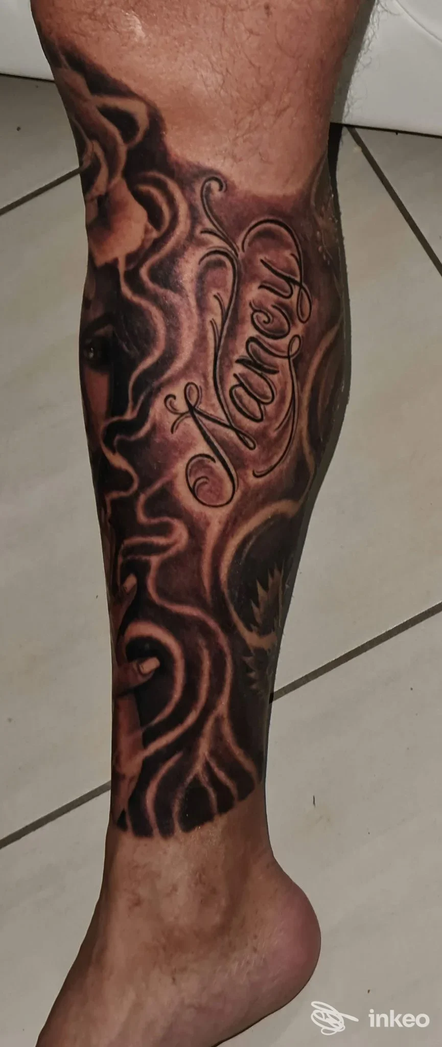 Calf tattoo con lettere eleganti verticali, stile realistico, colori scuri su pelle: Tattoo Art Studio, Aversa.