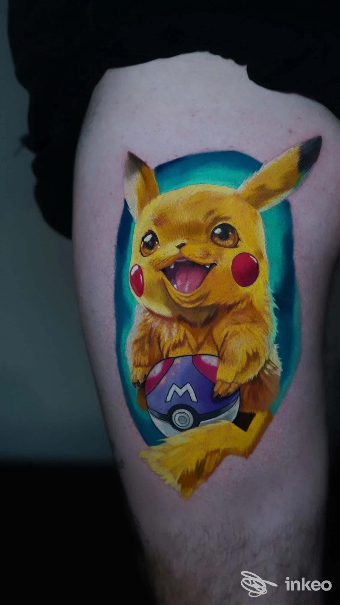 Tatuaggio su pelle di Pikachu felice con Pokéball sul braccio, colori vividi su sfondo azzurro.