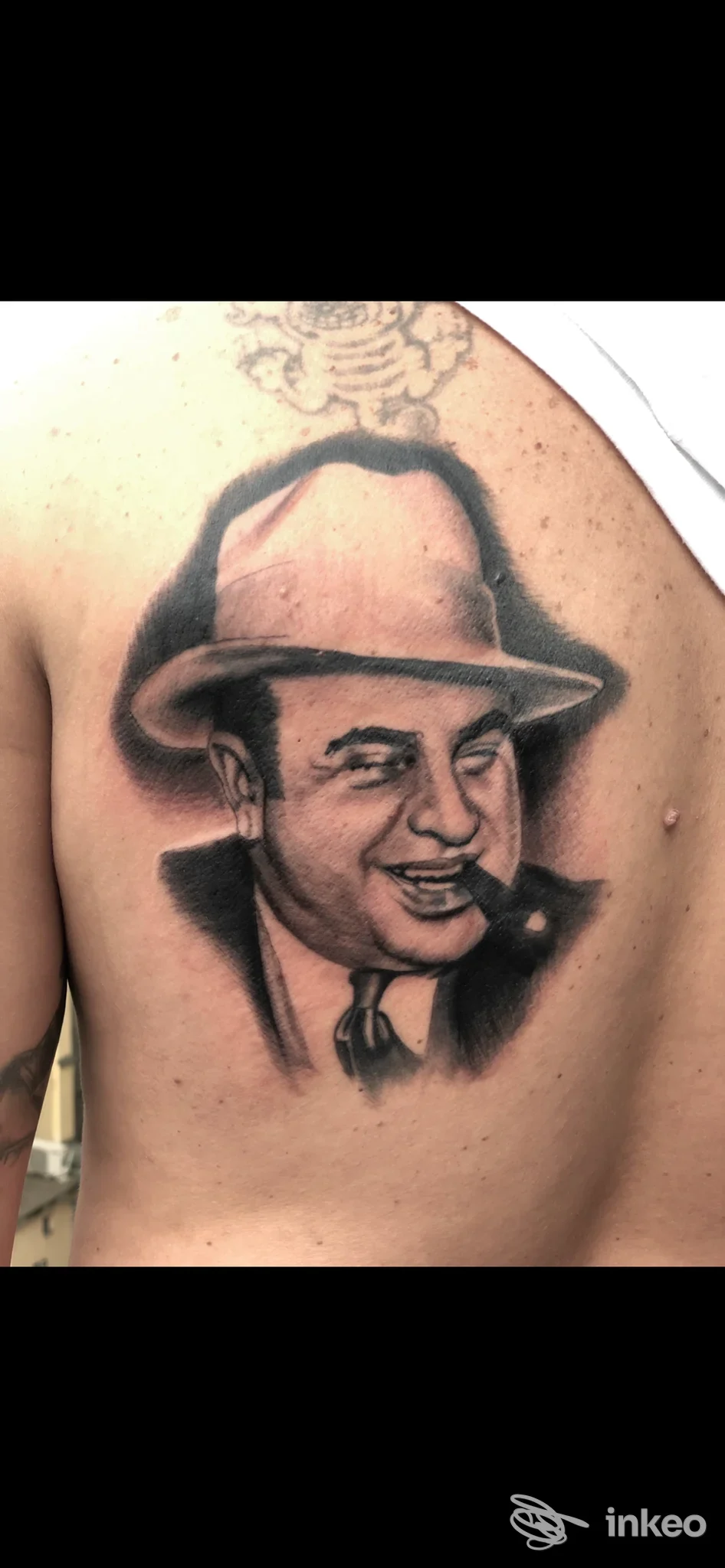 Tattoo realistico su schiena raffigurante un uomo con cappello, fumando una sigaretta, realizzato nello studio Emanuele Paioli a Napoli.
