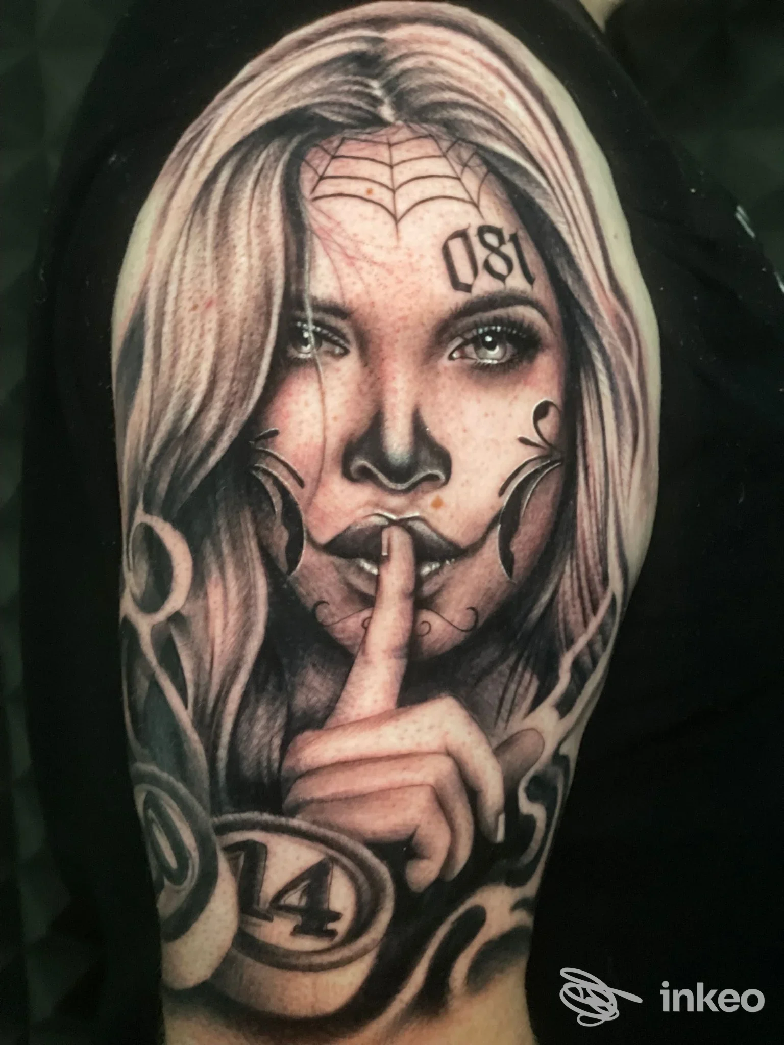 Tattoo su braccio realizzato da Emanuele Paioli a Napoli, ritraente una donna che alza un dito sulle labbra, stile realistico in bianco e nero.