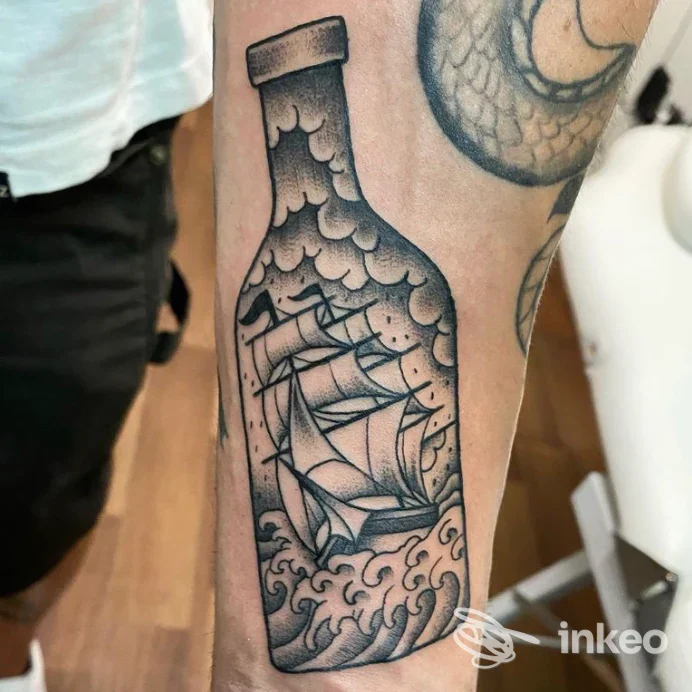 Tattoo su braccio raffigurante una bottiglia di vetro con vela e onde, realizzata in stile linework nero, con dettagli scolpiti sui bordi del disegno.