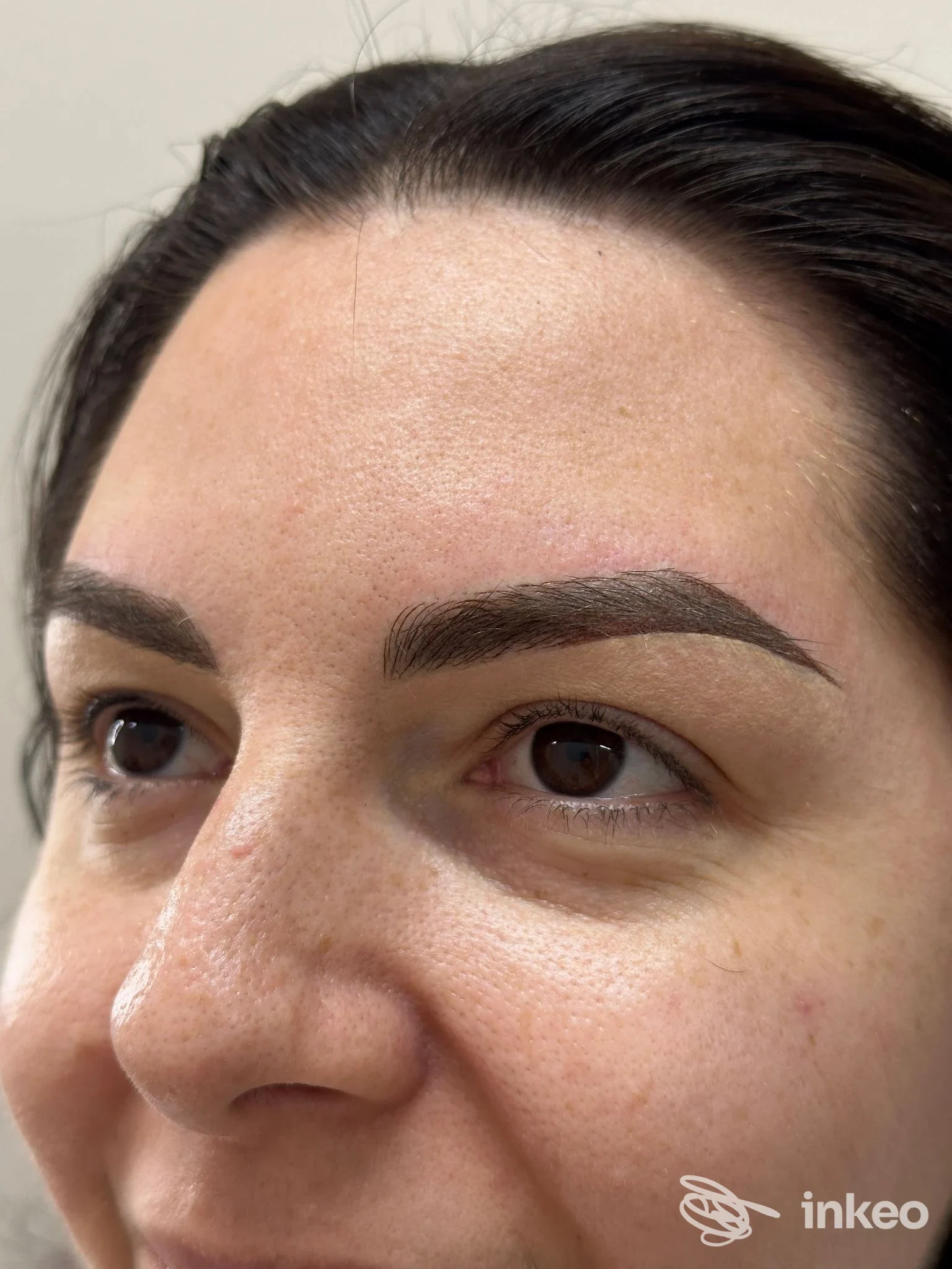 Primo piano di una persona con sopracciglia permanentemente pigmentate, visibile sulla pelle; ritratto parziale del viso senza overlay sociale.
