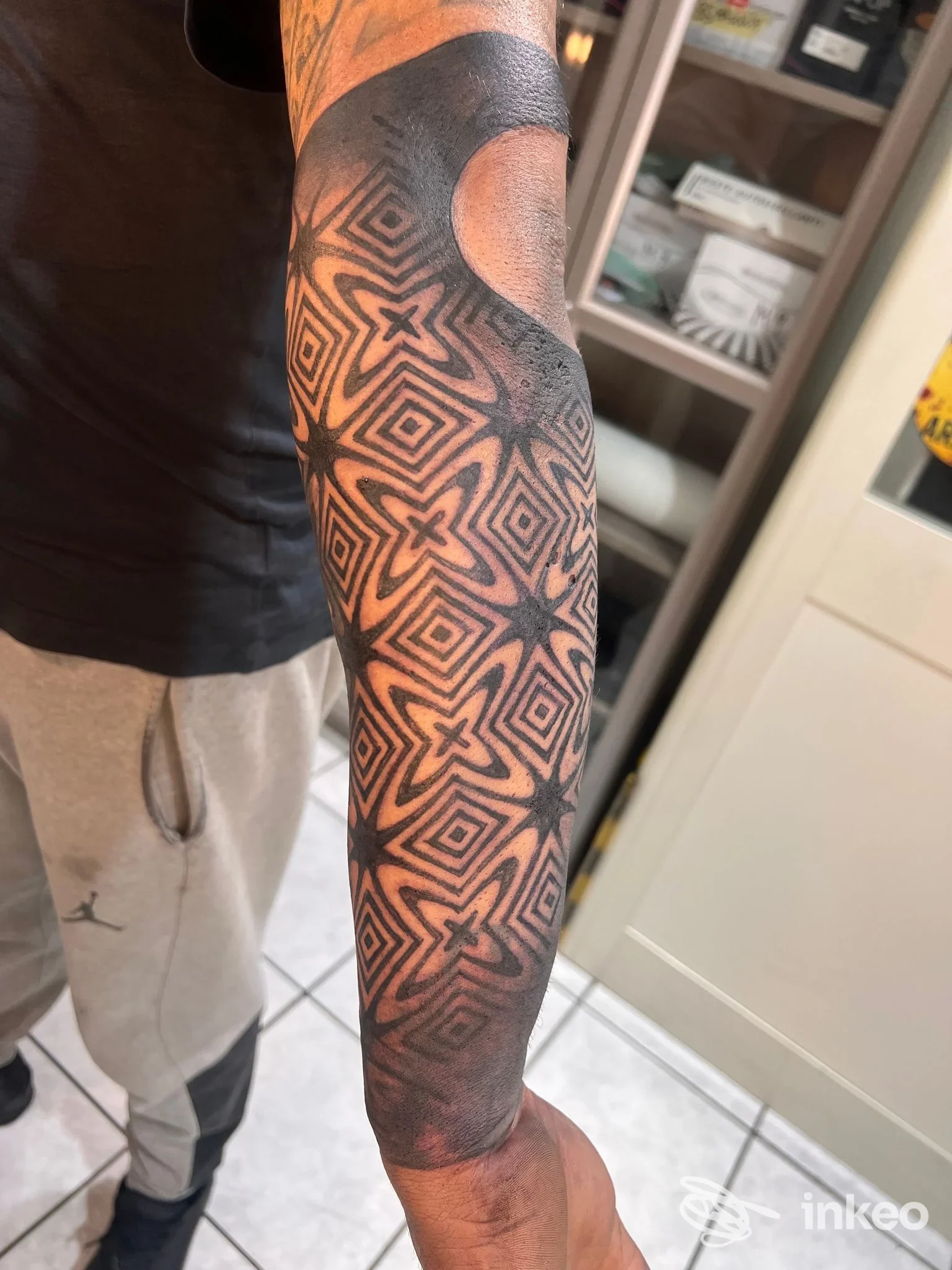 Tattoo geometrico su avambraccio realizzato da Ramificazioni Tattoo a Caserta, visibile in primo piano.