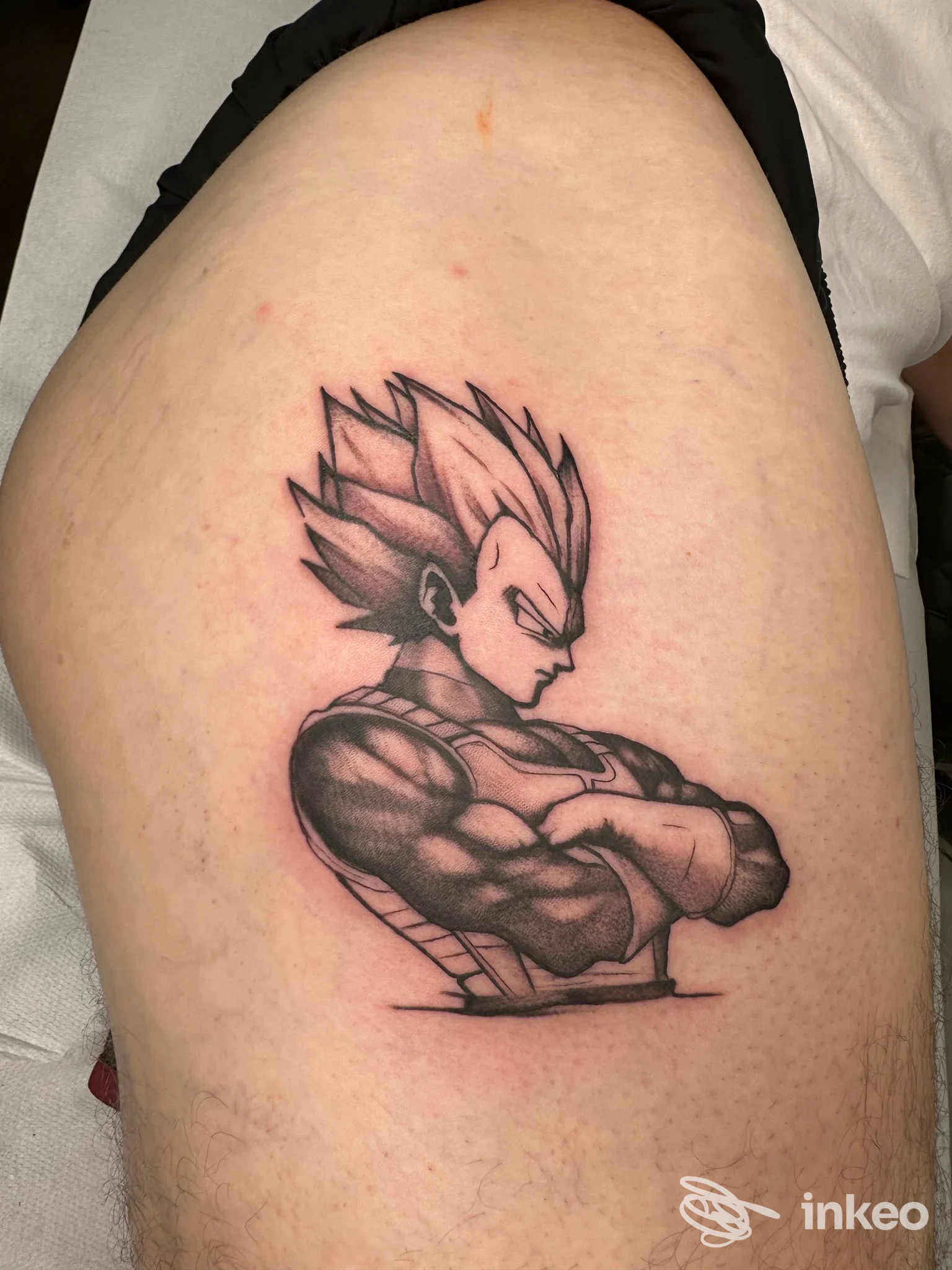 Tatuaggio in stile disegno anime su braccio: figura muscolosa con capelli spiky, espressione seria, linea di contorno scura e shading dettagliato.