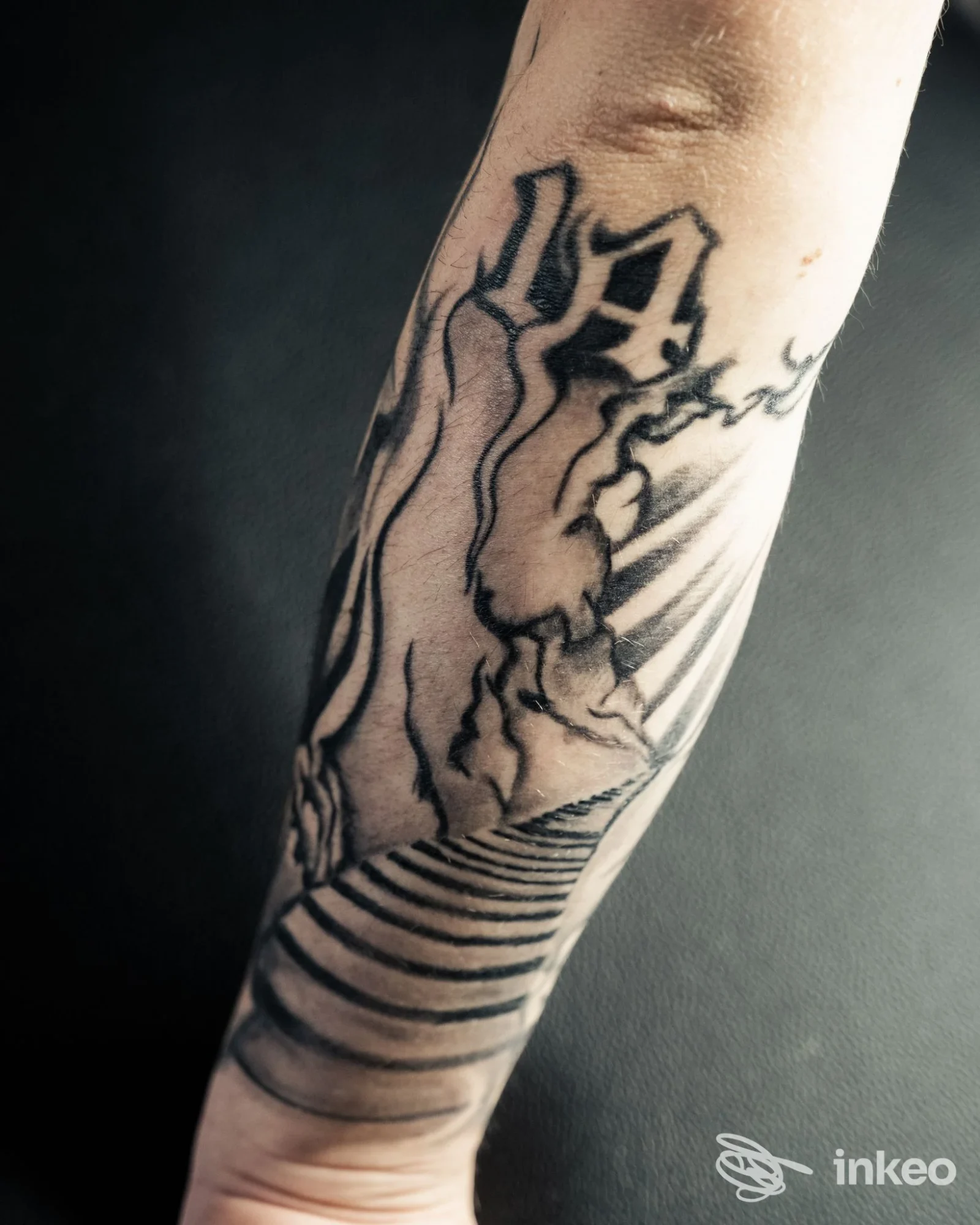 Dettaglio di un braccio con tatuaggio nero su pelle, stile linework, realizzato presso Drop Ink Tattoo Studio a Velina.