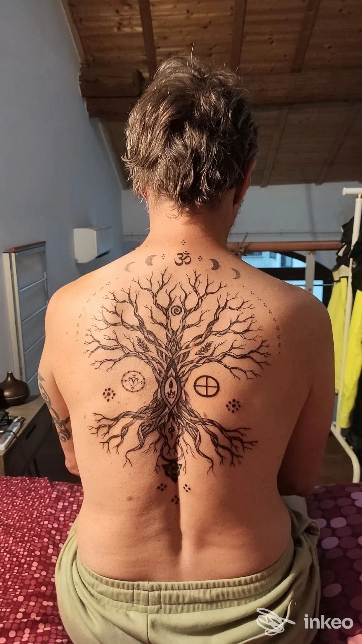 Tatuaggio sul dorso raffigurante un albero con rami intricati, centrato lungo la colonna. La pelle è visibile senza volto.