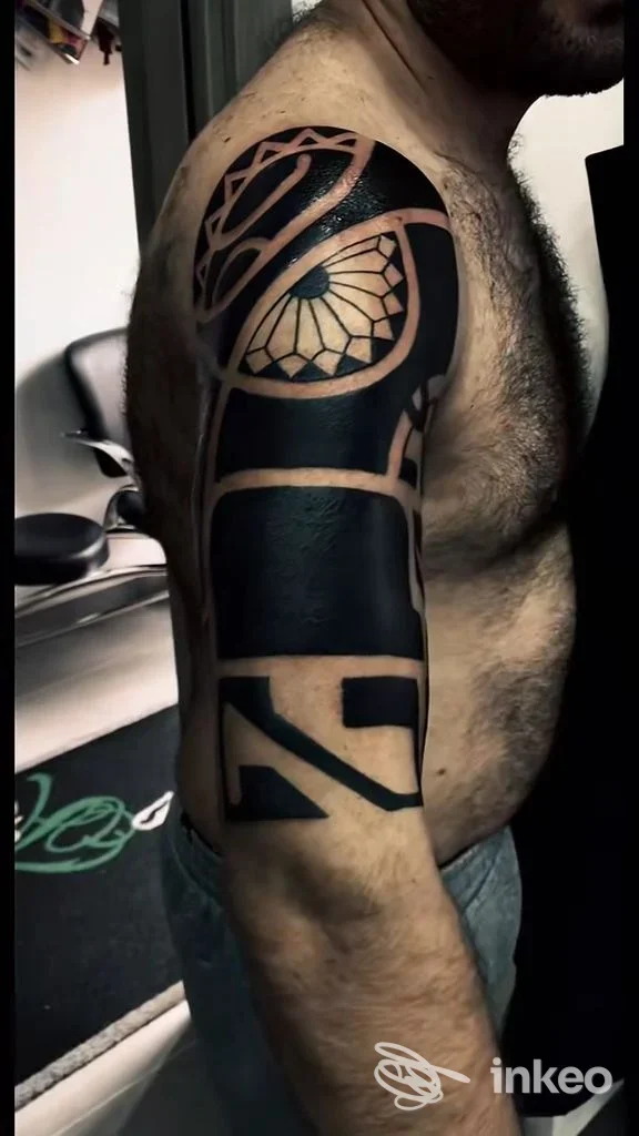 Tattoo sul braccio di un uomo, stile geometrico con pieni di colore nero, visibile su pelle nuda, senza volto inquadrato. Studio Tattoo Art, Boscoreale.