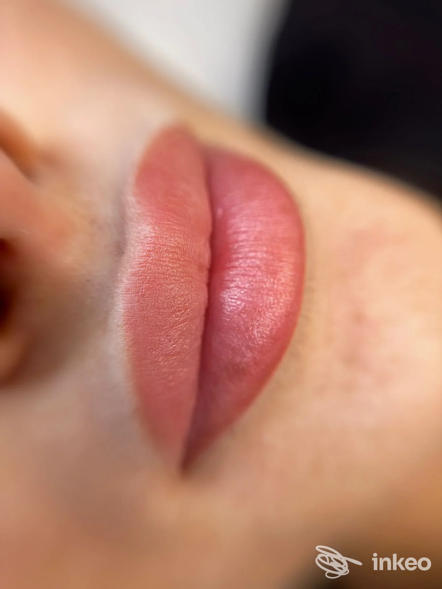 Labbra colorate con trucco permanente visibile sulla pelle, in primo piano, tonalità rosa e rosso, senza testo o watermark.