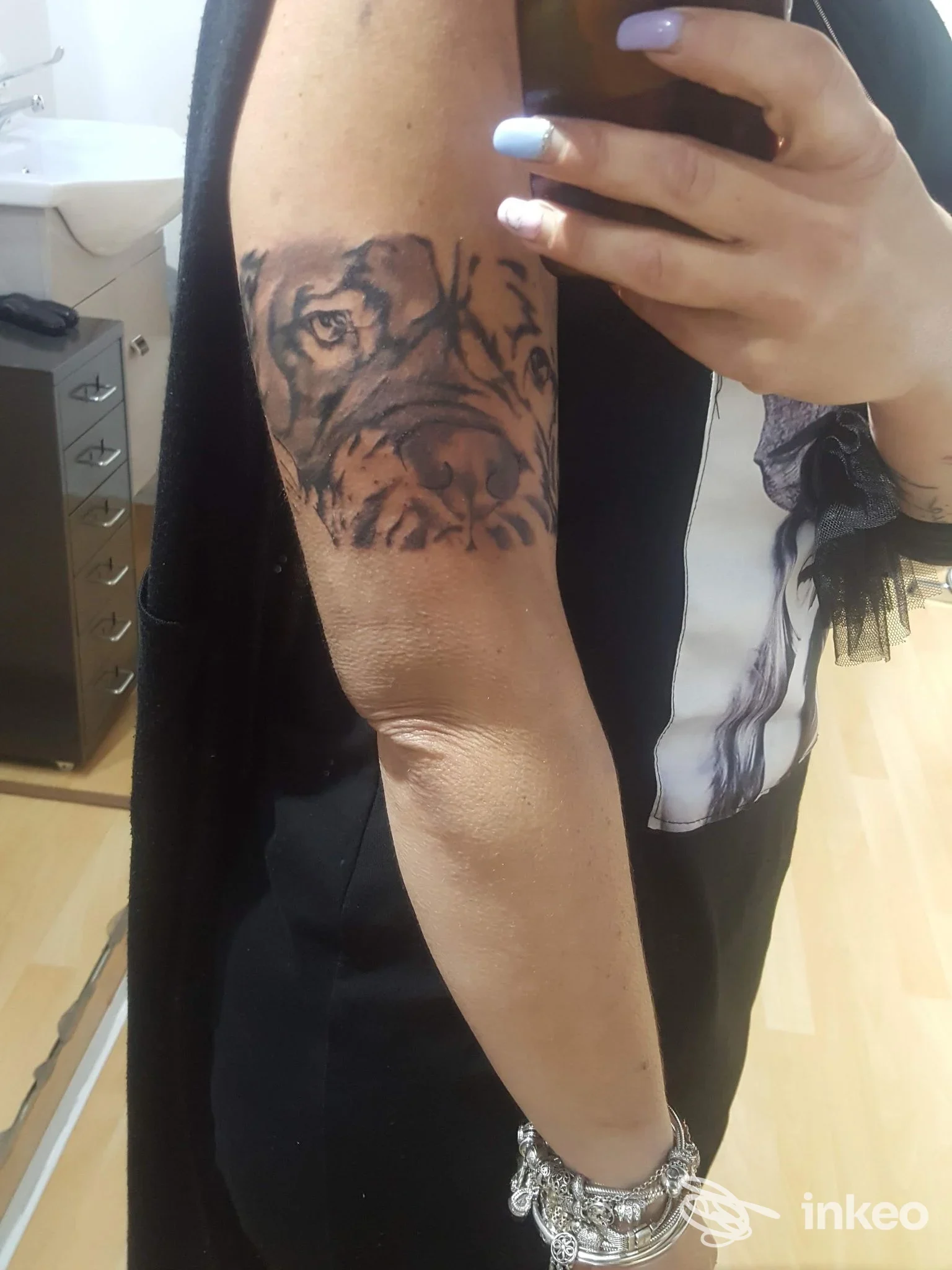 Braccio di una persona con un tatuaggio realistico a tema animale, visibile dall’esterno, senza sovrapposizioni o volto interamente visibile.