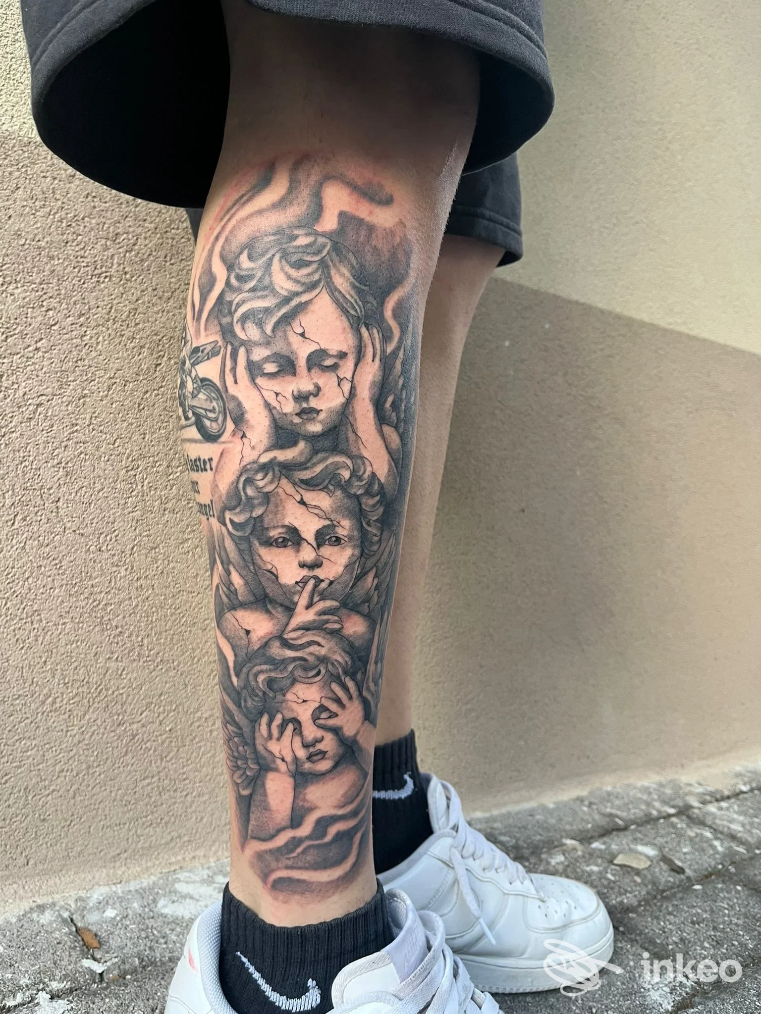 Tattoo visibile sulla gamba di una persona, raffigurante volti in stile realistico, con ombreggiature e linee ben definite