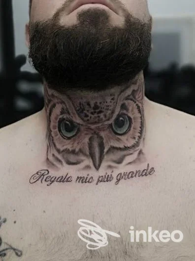 Tatuaggio realistico di un gufo sul collo di un uomo, realizzato dal Vik-Ink Tattoo di Melito di Napoli, visibile sotto la barba. testi corsivi sul basso collo.