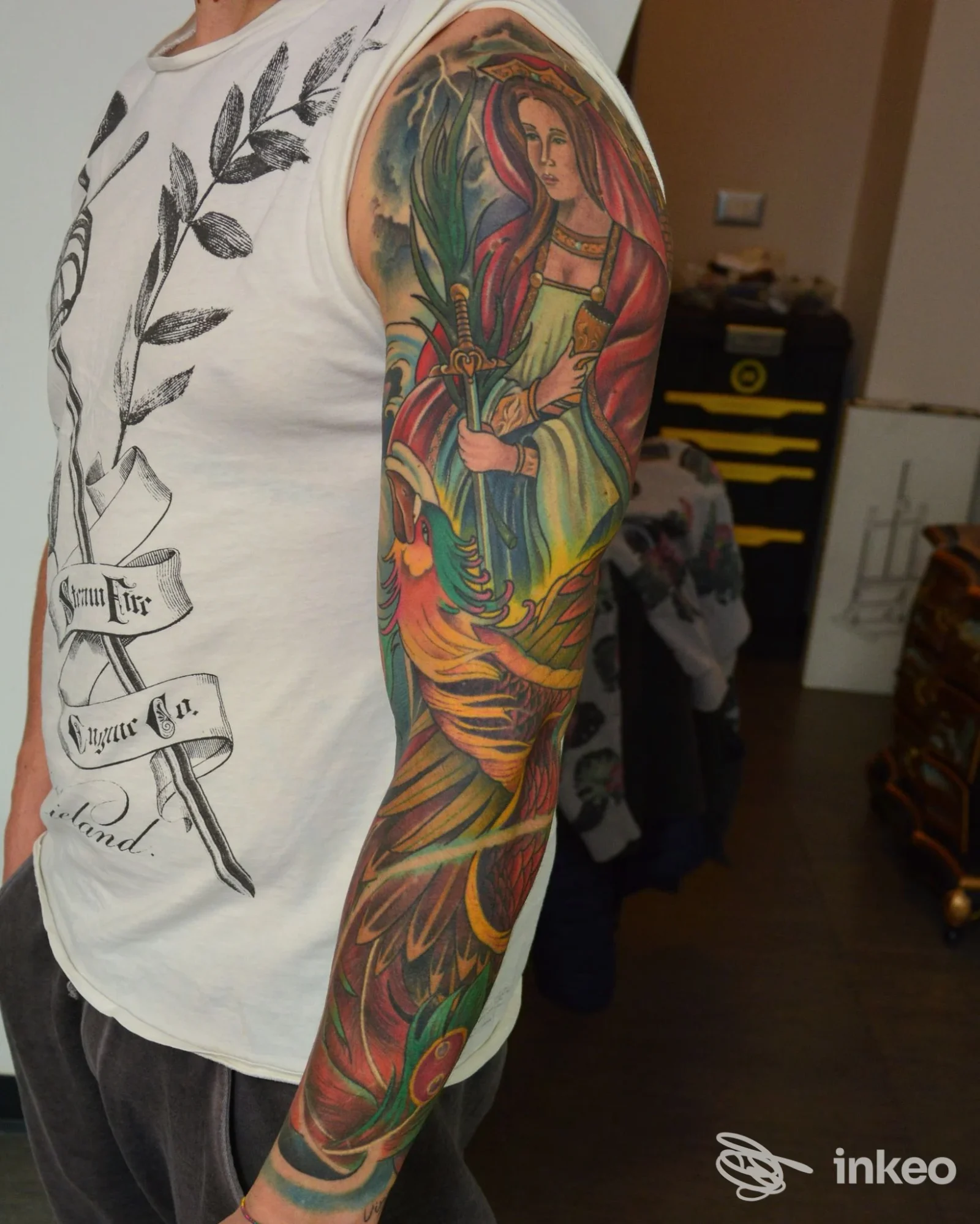 Braccio di una persona con tatuaggio colorato stilizzato raffigurante figura femminile e flora, tatuaggio esteso sul brascia.