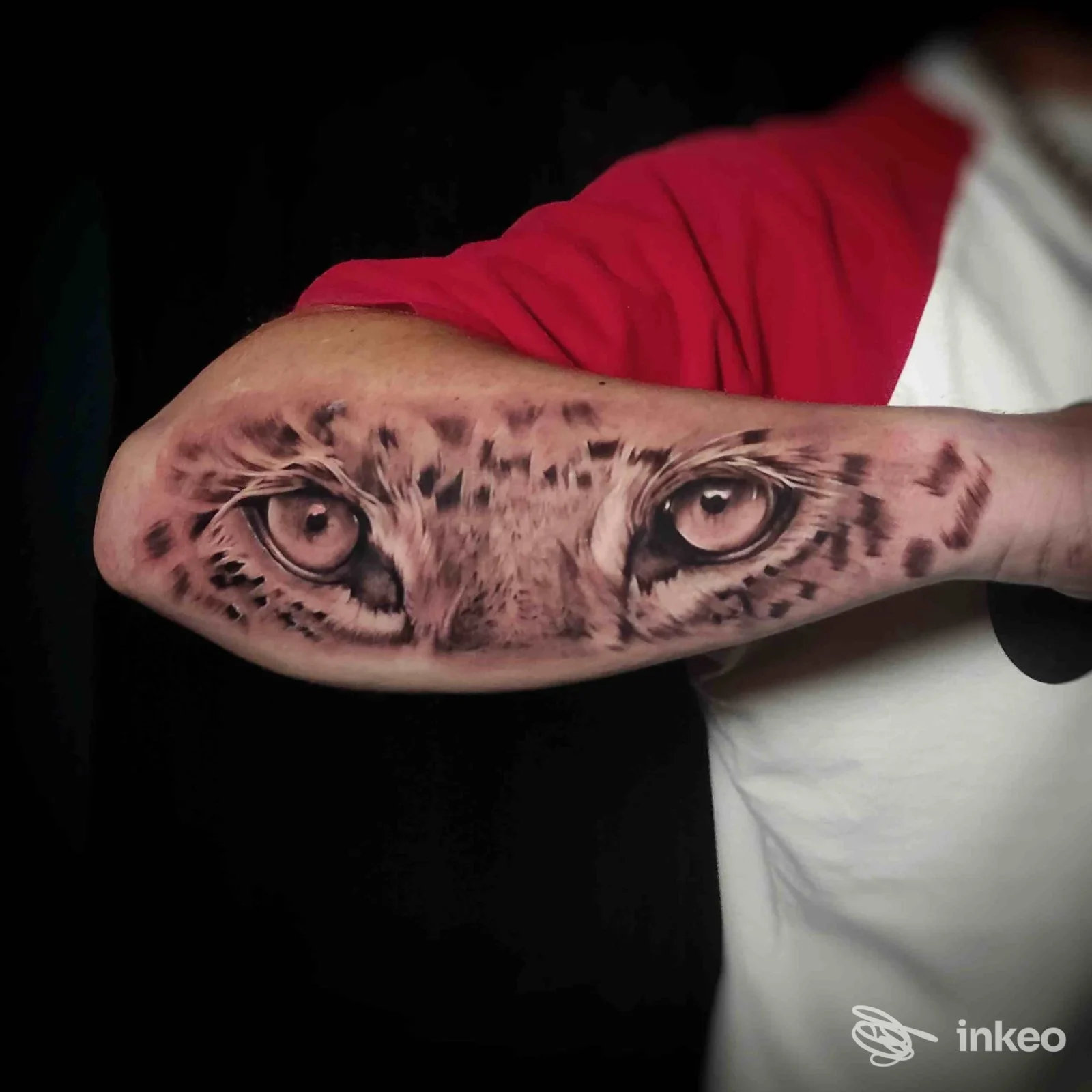Tattoo realistica su avambraccio raffigurante due grandi occhi di leopardo, realizzata nello studio Atramento Tattoo a Salerno.