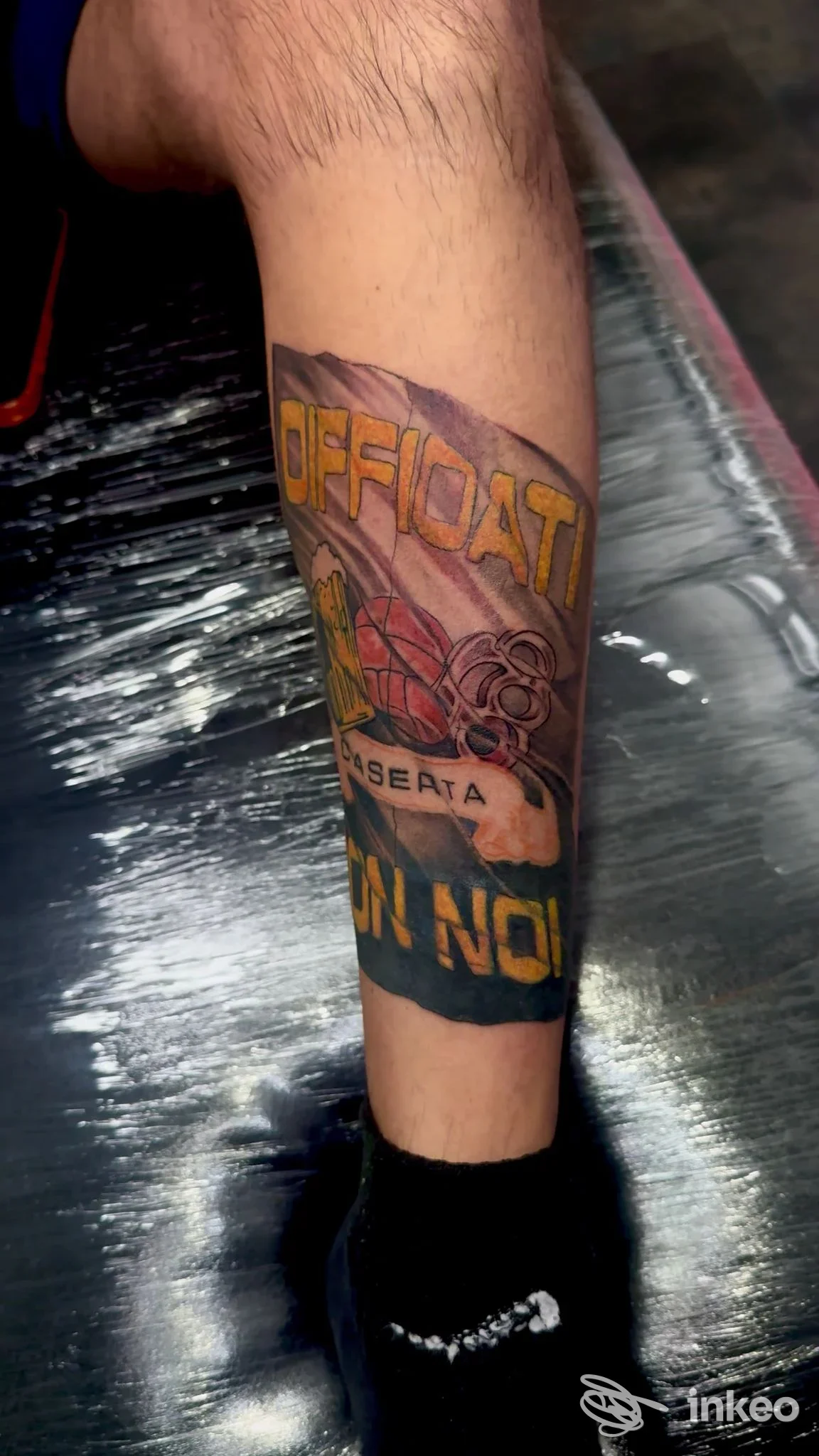 Tattoo visibile chiaramente sulla gamba, colori vividi e linee nette; senza volto visibile, ambientazione interna e senza watermark sociale, studio Inkimmersion a Caserta.