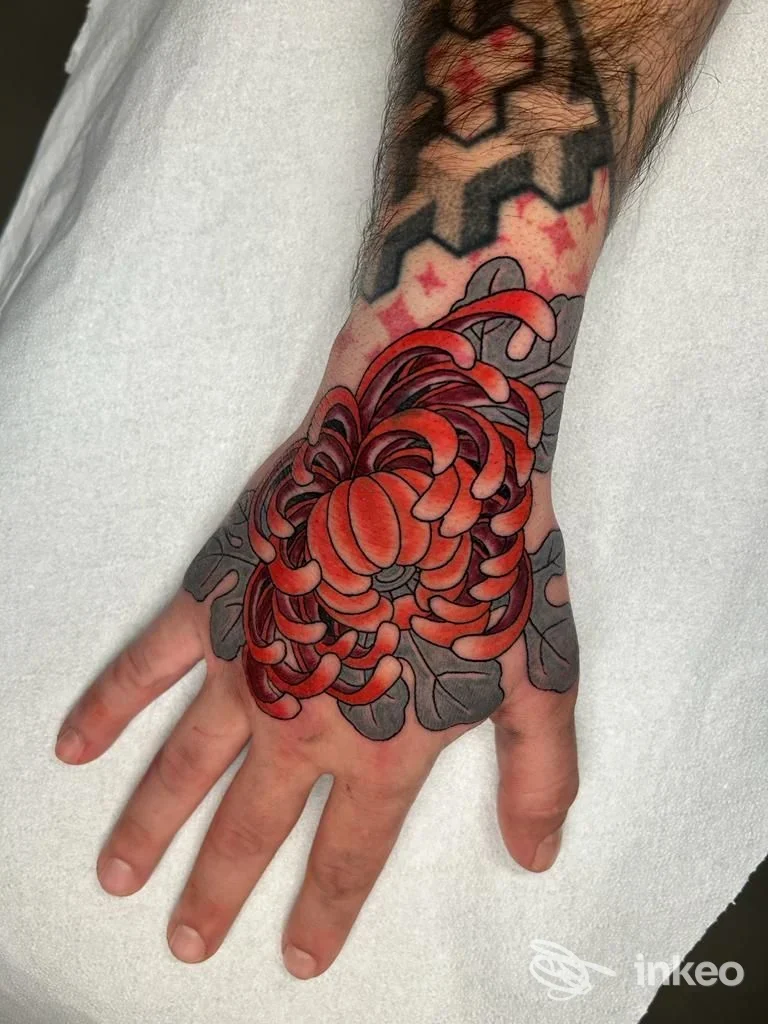 Tatuaggio reale sul dorso della mano, stile floreale rosso con contorni scuri, visibile su pelle chiara; studio Don't Cry Tattoo Collective a Napoli.