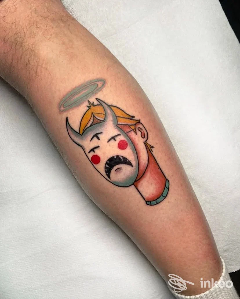 Tatuaggio sull'avambraccio raffigurante una testa demoniaca stilizzata con aureola, colori vividi su pelle chiara; realizzato dallo studio Don't Cry Tattoo Collective a Napoli.
