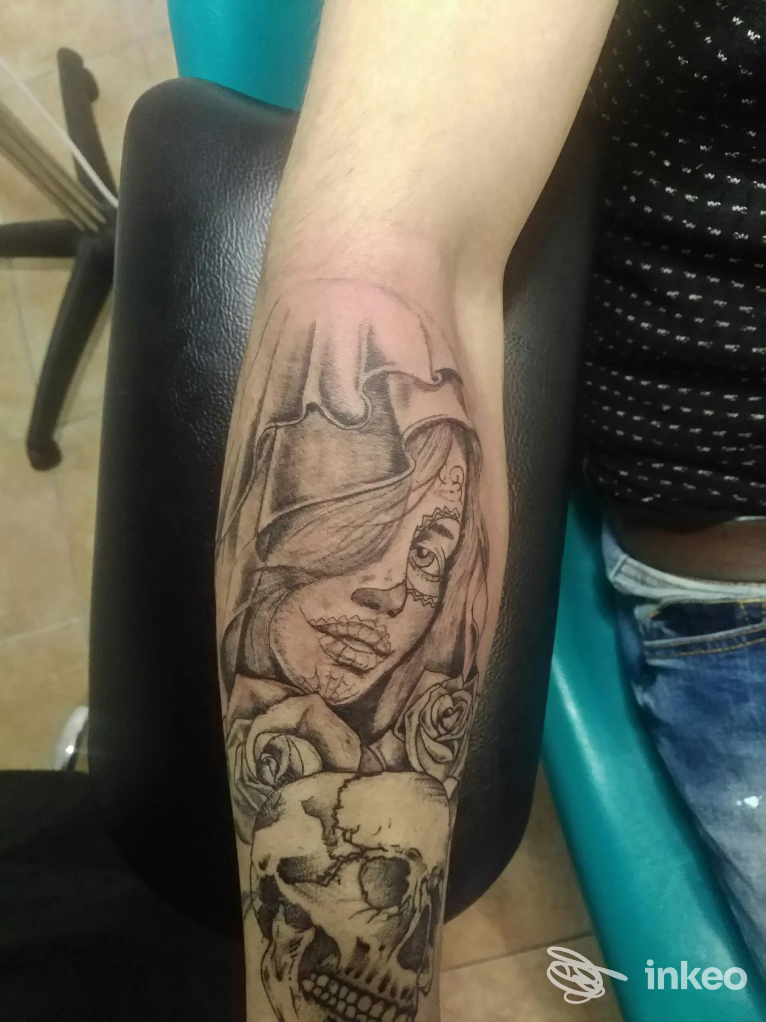 Piercing tattoo su avambraccio raffigurante una testa di donna velata e un teschio, eseguito in stile line work su pelle chiara.