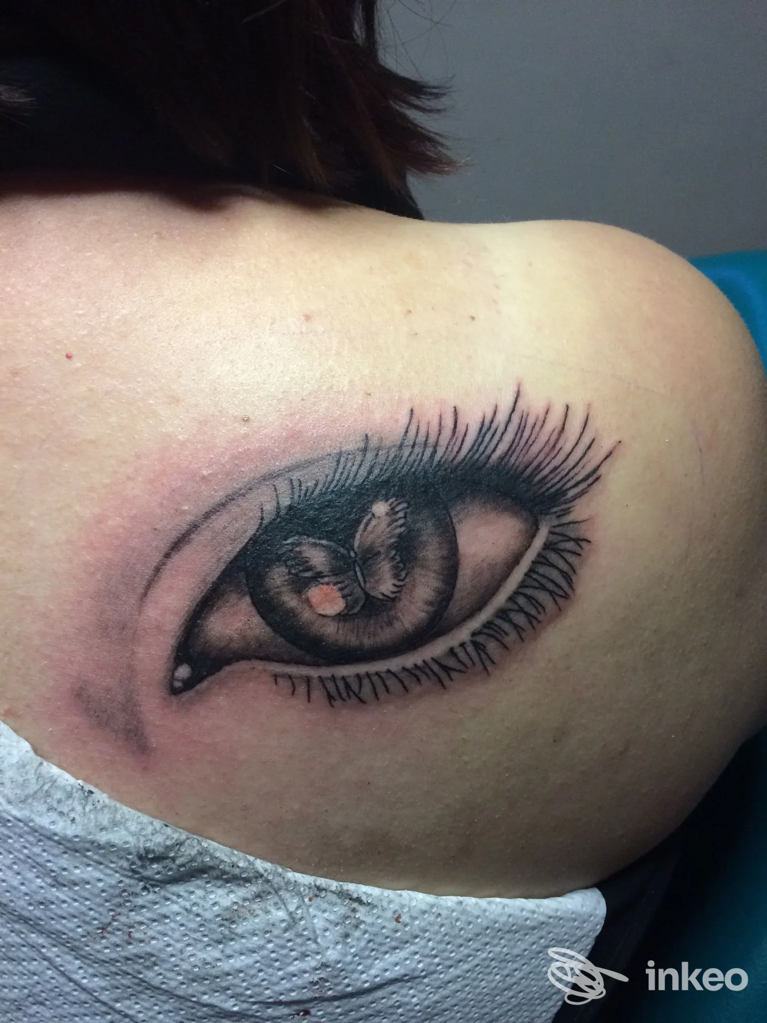 Tattoo realistico di un occhio sulla spalla, disegno in nero su pelle chiara, realizzato in stile realistico, visibile solo l’area della spalla/ingresso. Studio Tribalia Tattoo a.p.s., Grottaminarda.