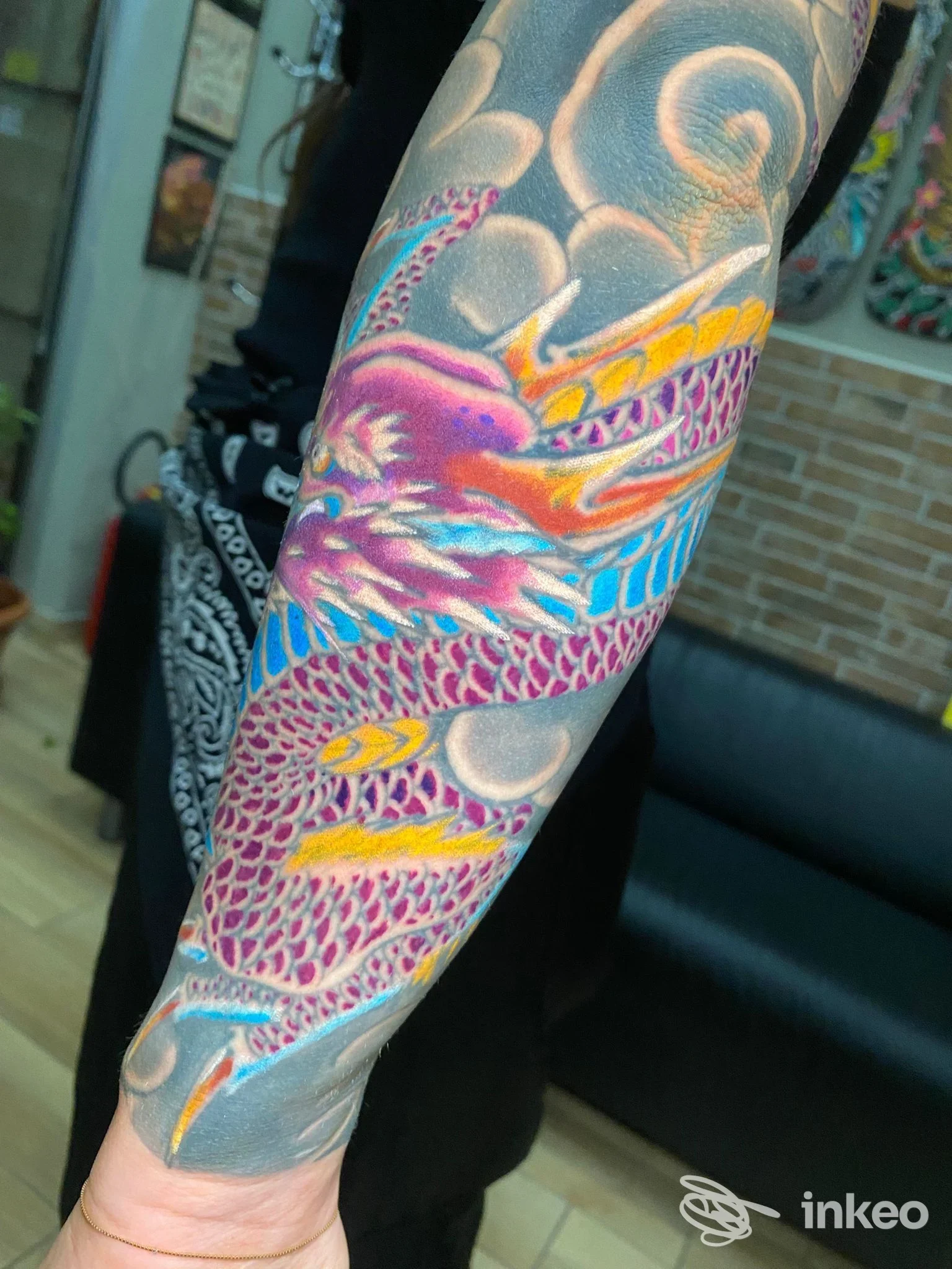 Tattoo colorato di un drago sul braccio, visibile in primo piano con sfondo neutro; realizzato su pelle, stile vivace e definito. Studio VitaLe Tattoo, Napoli.