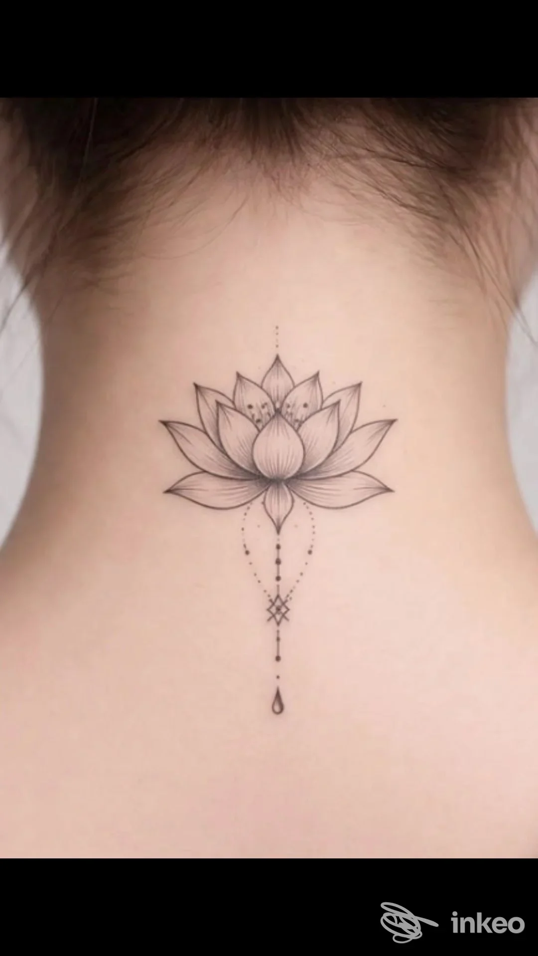 Tatuaggio sul retro del collo raffigurante un loto stilizzato con dettagli shading e un pendente centrale, visibile sulla pelle chiara.