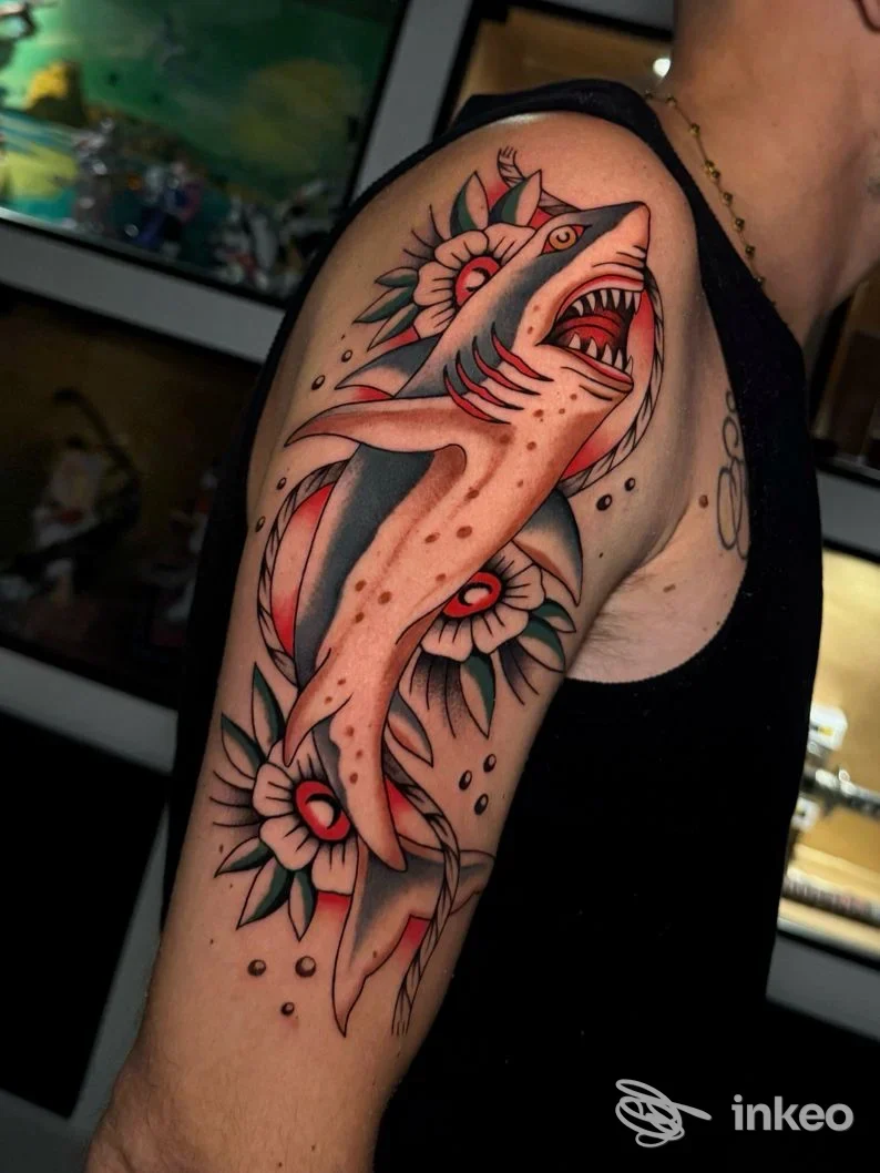 Tatuaggio artigianale sul braccio raffigurante creature mitologiche con fiori, realizzato da DAT Tattoo Studio a Marano di Napoli.