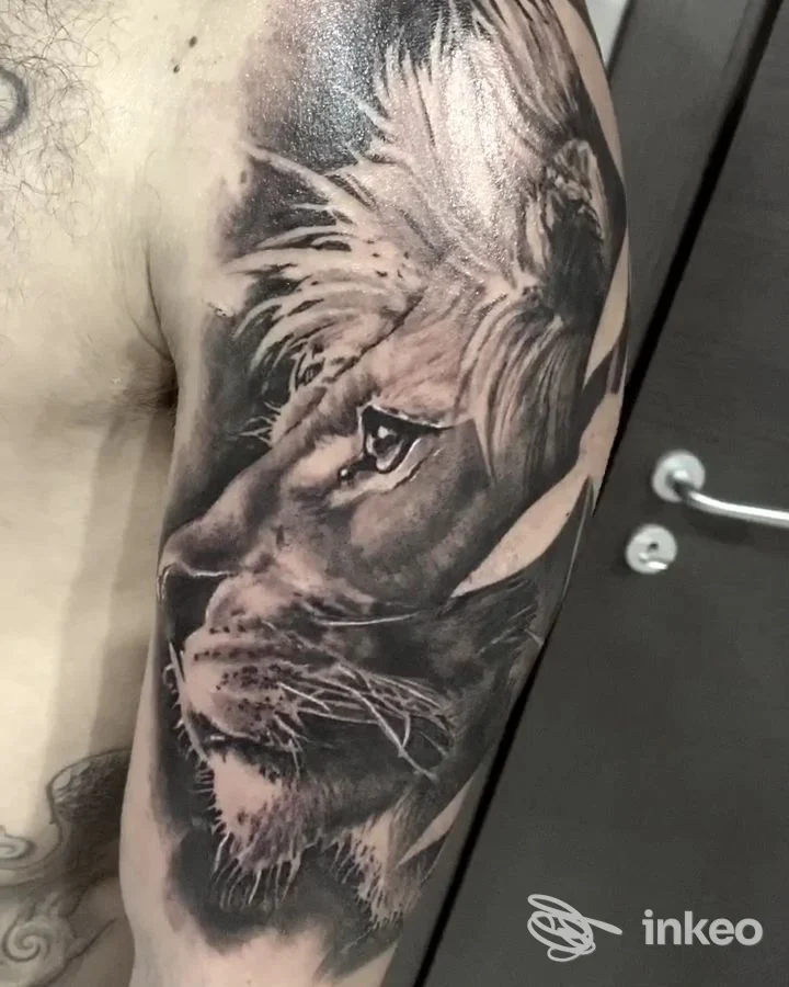 Ritratto realistico di leone tatuato sulla pelle, eseguito presso The Raimondi's General Tattoo a Napoli.