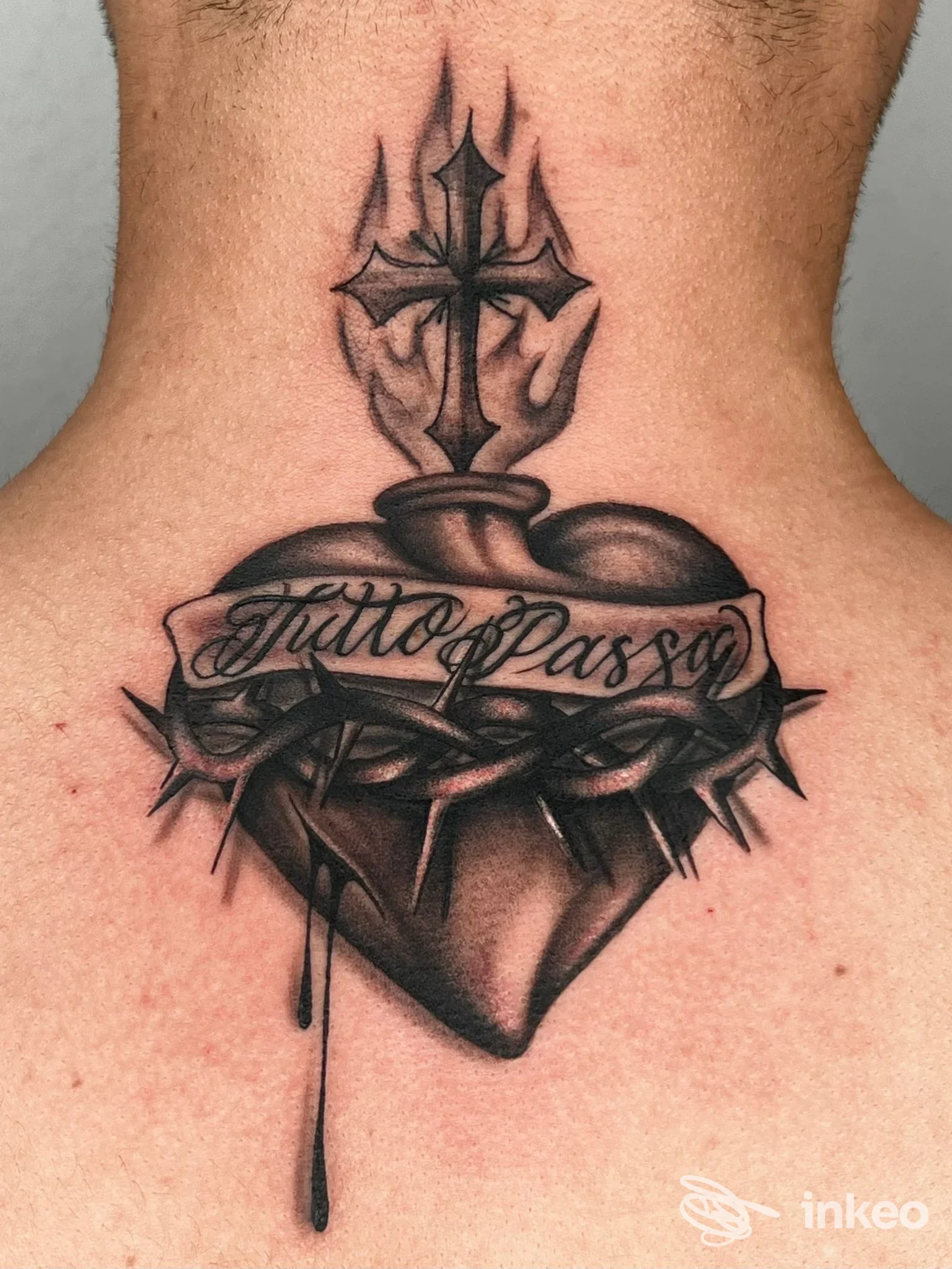 Tatuaggio su nuca raffigurante cuore trafitto da spada con fascia decorativa e testo scriptato “TattooPass” attraversante, con goccia di inchiostro che scende.