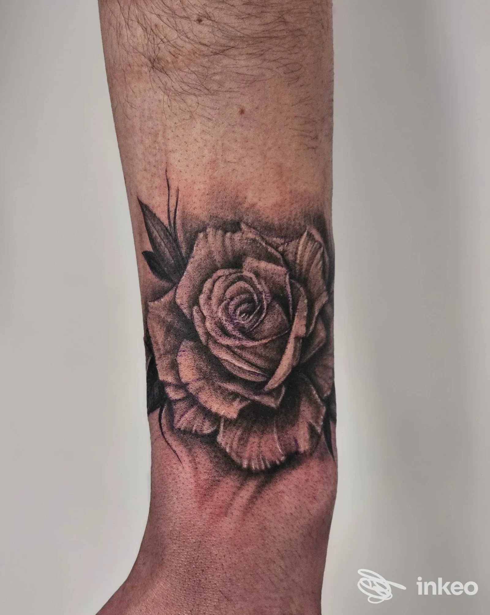 Tatuaggio realistico di rosa in tonalità nere e grigio sull'avambraccio, realizzato da Tilt Tattoo E Piercing a Avellino.