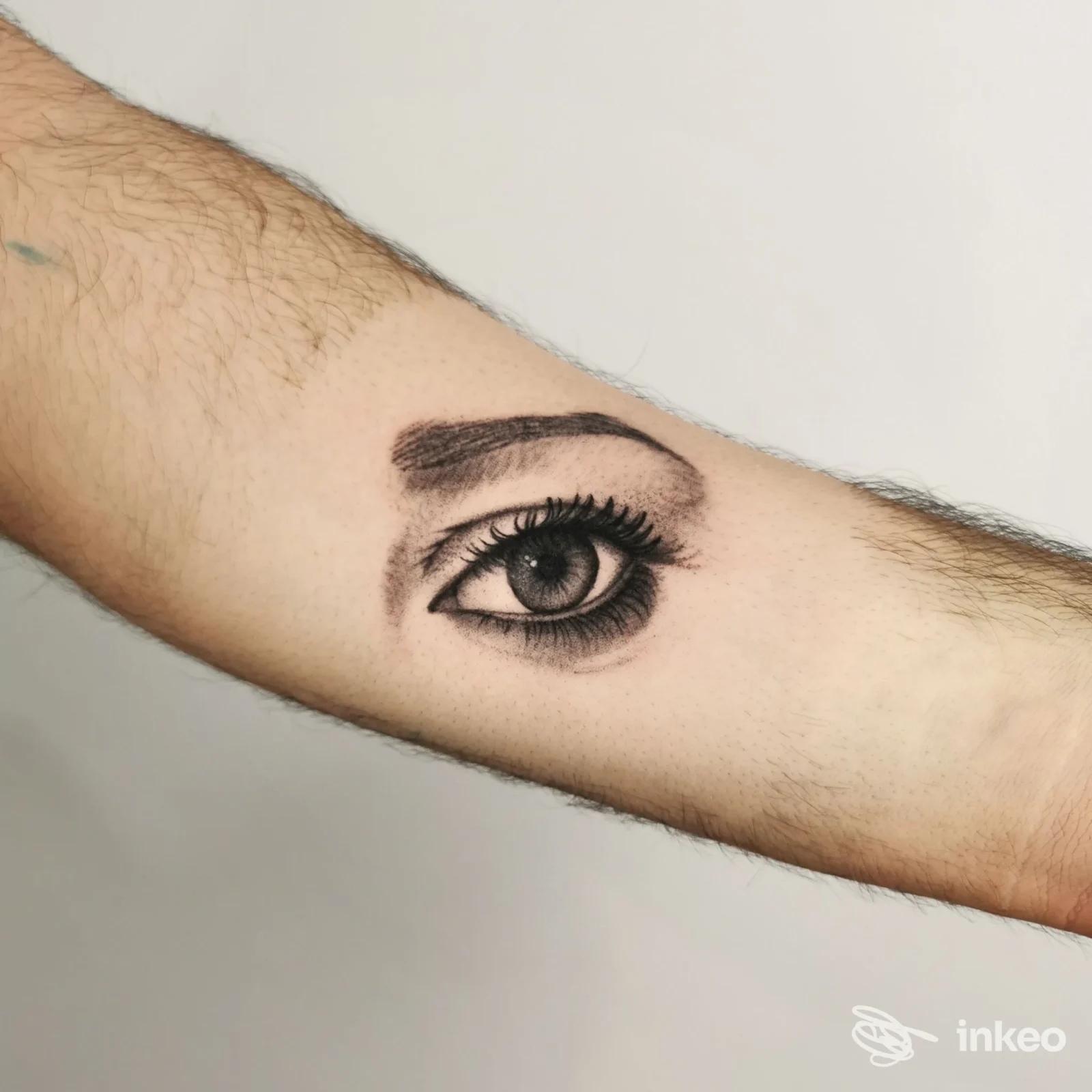 Tattoo realistico di un occhio su una porzione di braccio, visibile come disegno sulla pelle senza viso; studio Agophobia Tattoo Shop, Baiano.