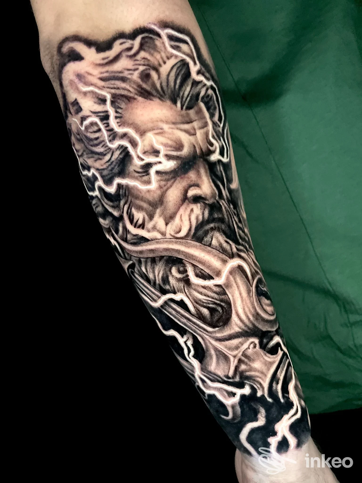 Tatuaggio realistico su avambraccio, tonalità scure con linee bianche evidenti e sfumature. Nessun volto visibile, superficie pelle umana.