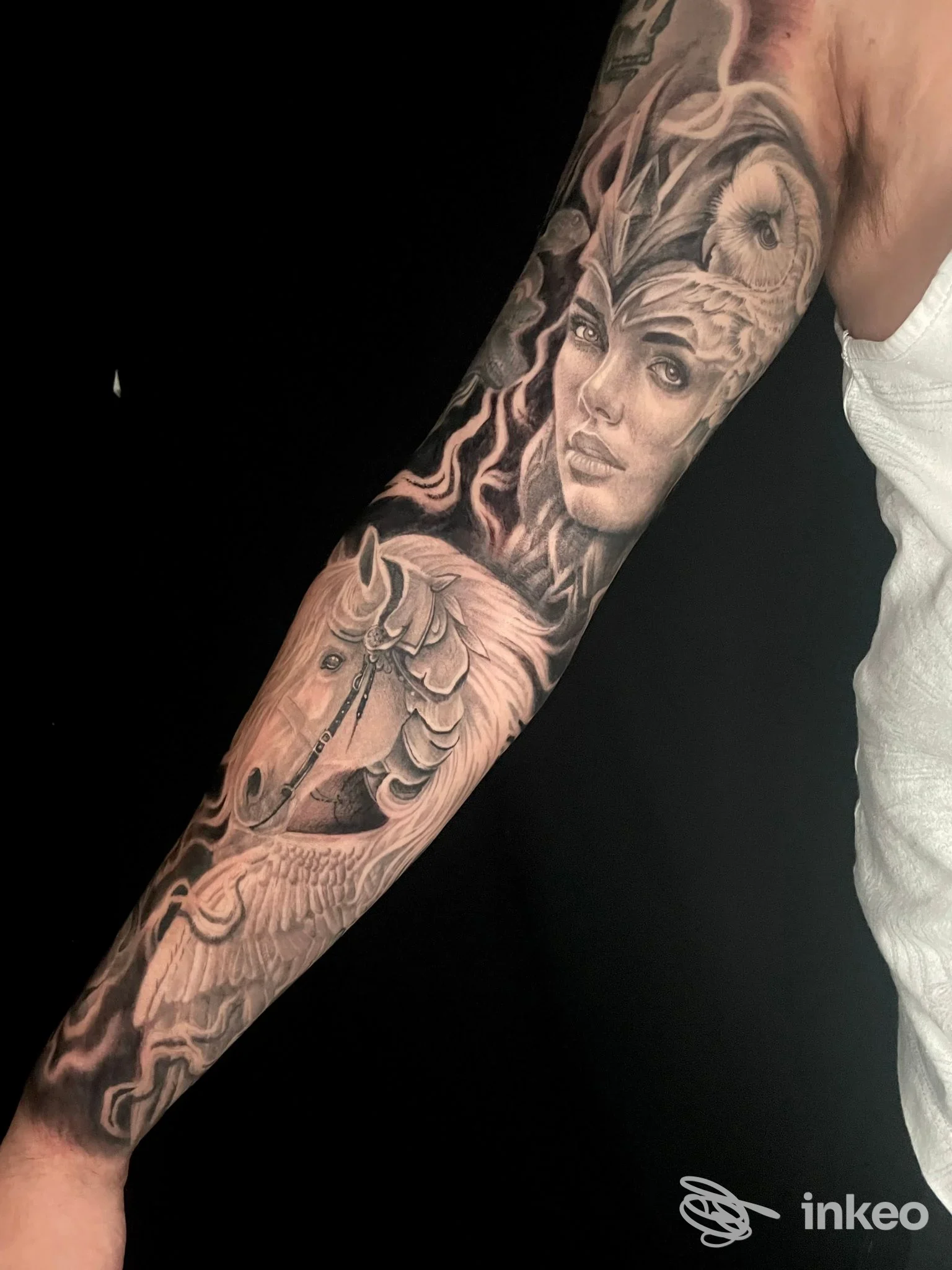 Tattoo sul braccio raffigurante una testa di cavallo e una figura femminile, realizzato su pelle, tonalità in bianco e nero, eseguito da Floky ink.