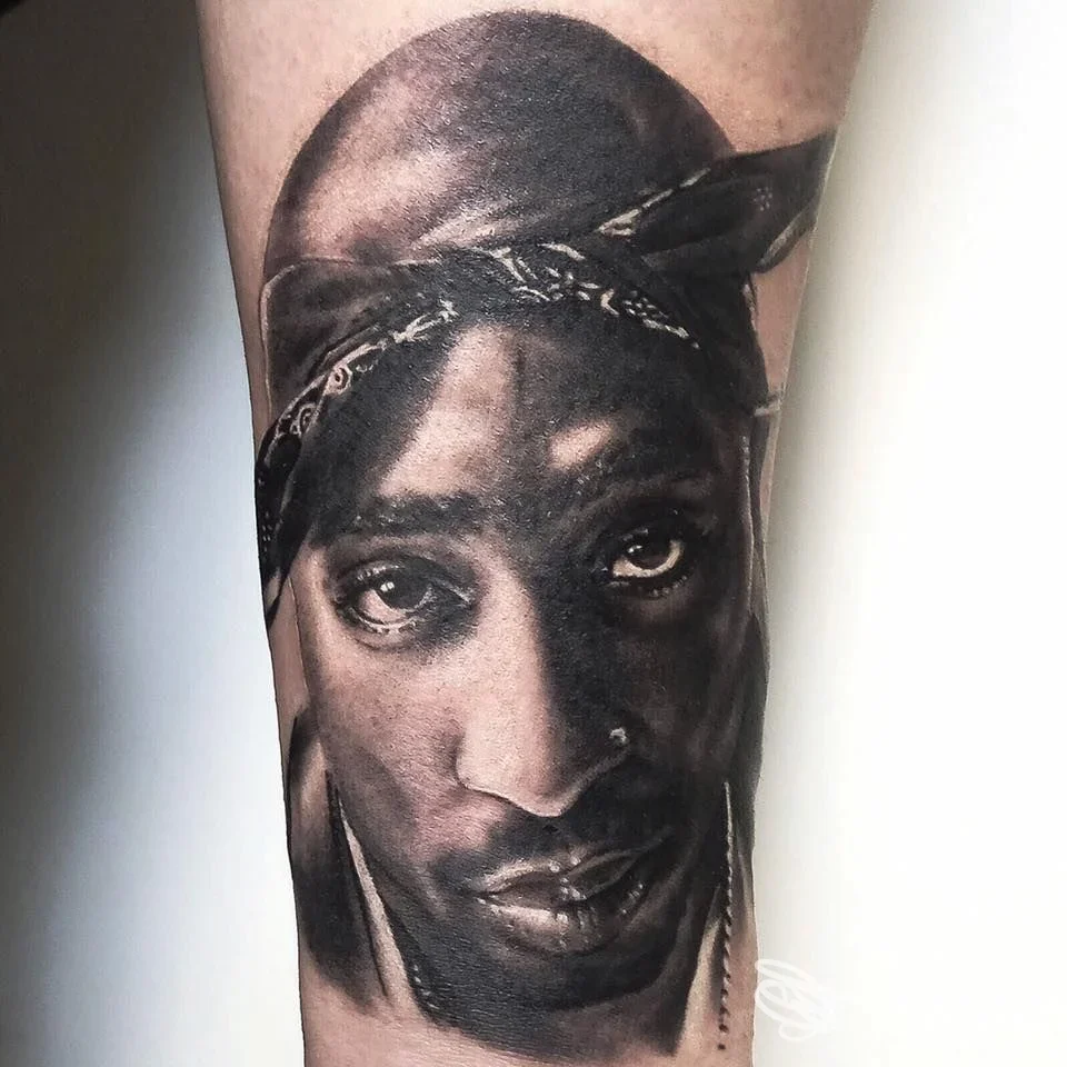 Ritratto realistico in bianco e nero su avambraccio, tatuaggio su pelle eseguito da INKdustria Tattoo a Riccione.