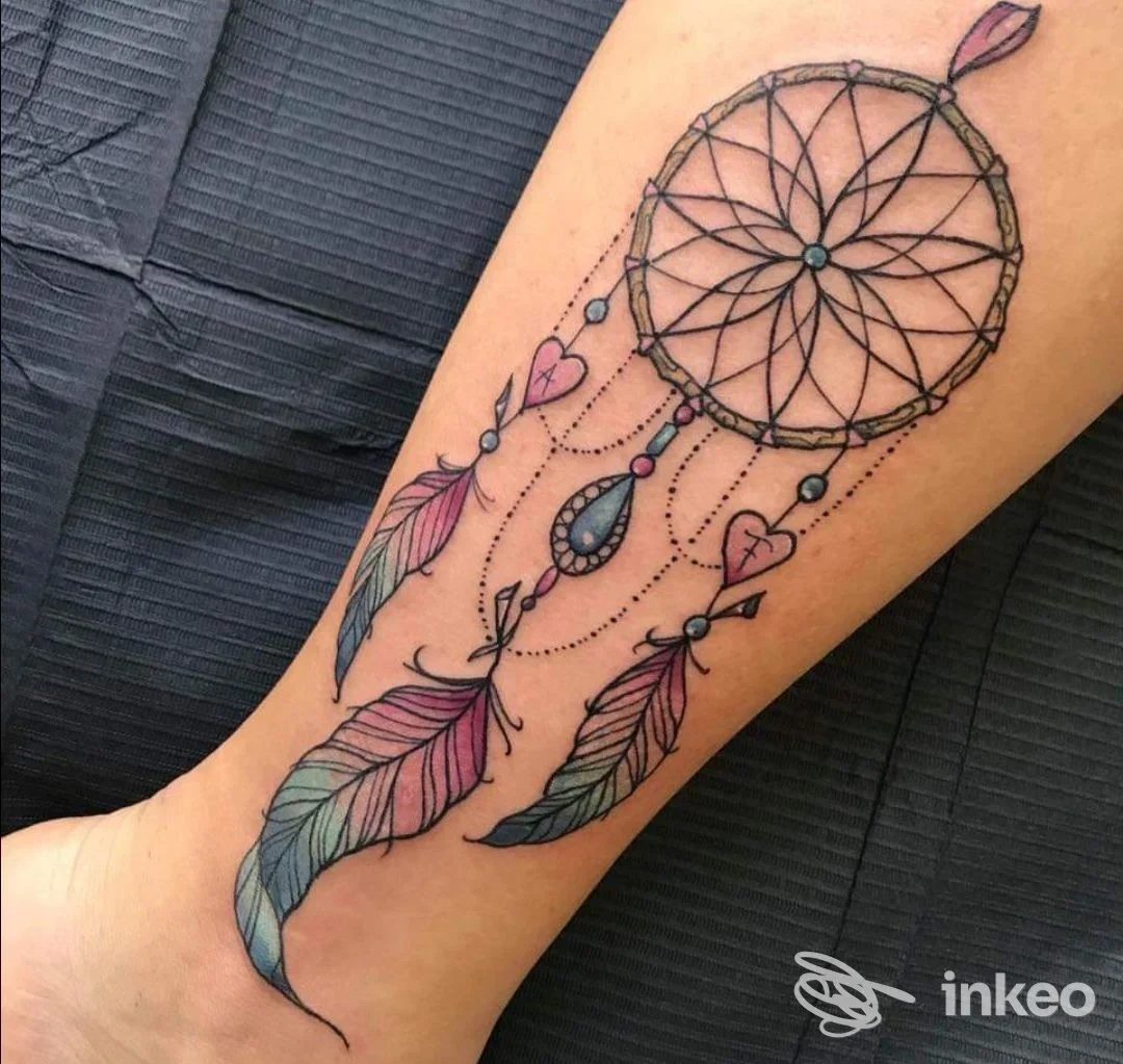 Tattoo sul braccio raffigurante un dreamcatcher con piume colorate, eseguito sulla pelle reale, nessun logo o overlay visibile, studio LaMalaFemmena a Mercato Saraceno.