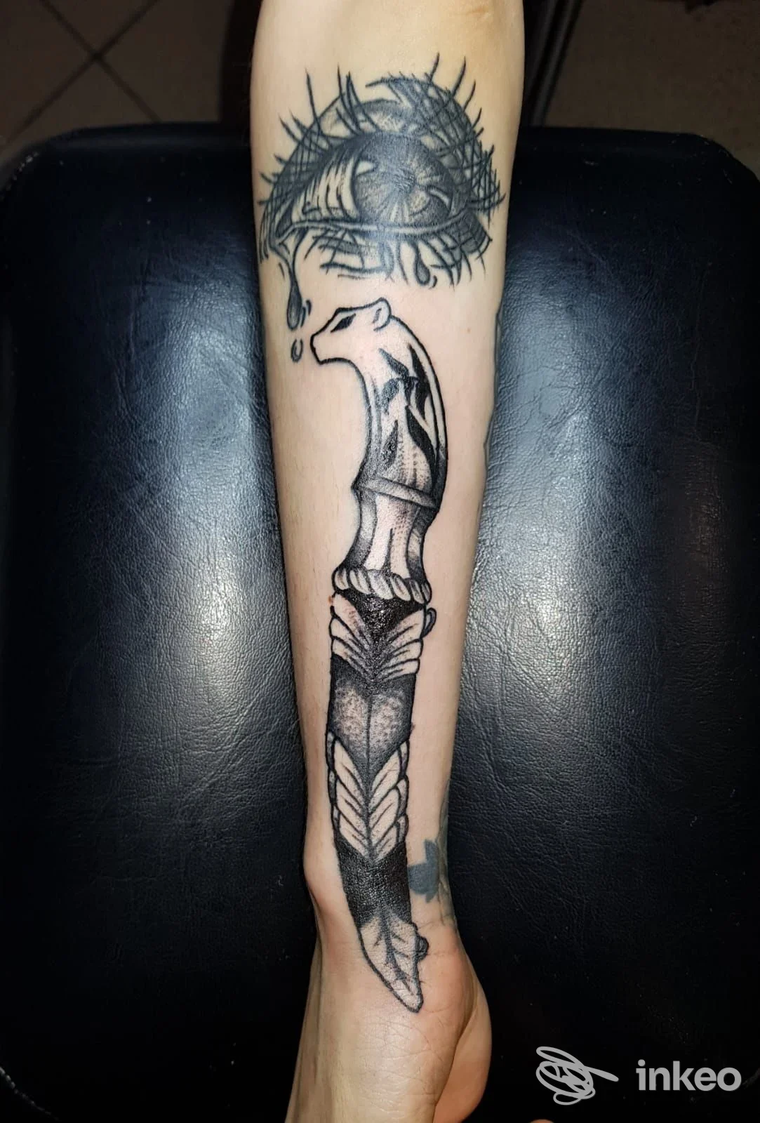 Tattoo visibile sull'avambraccio: lama decorata e motivo ad arco, accompagnati da un elemento circolare con raggi. Studio History of my Skin Tattoo Studio a Fidenza.