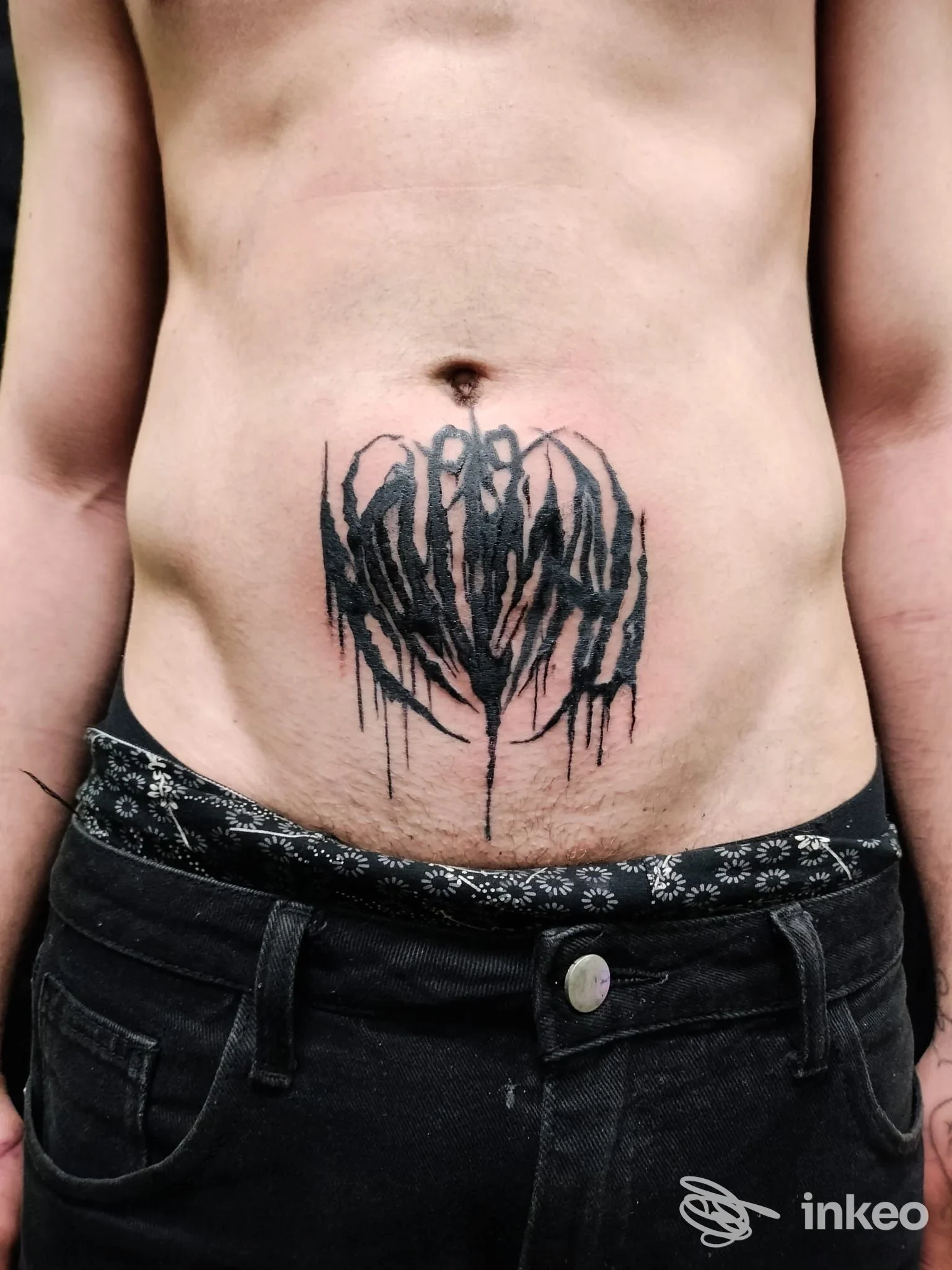 Tattoo nero a effetto dripping sull’addome di una persona, pubblicato dallo studio History of my Skin Tattoo Studio a Fidenza, nessun overlay visivo o testo esterno presente.