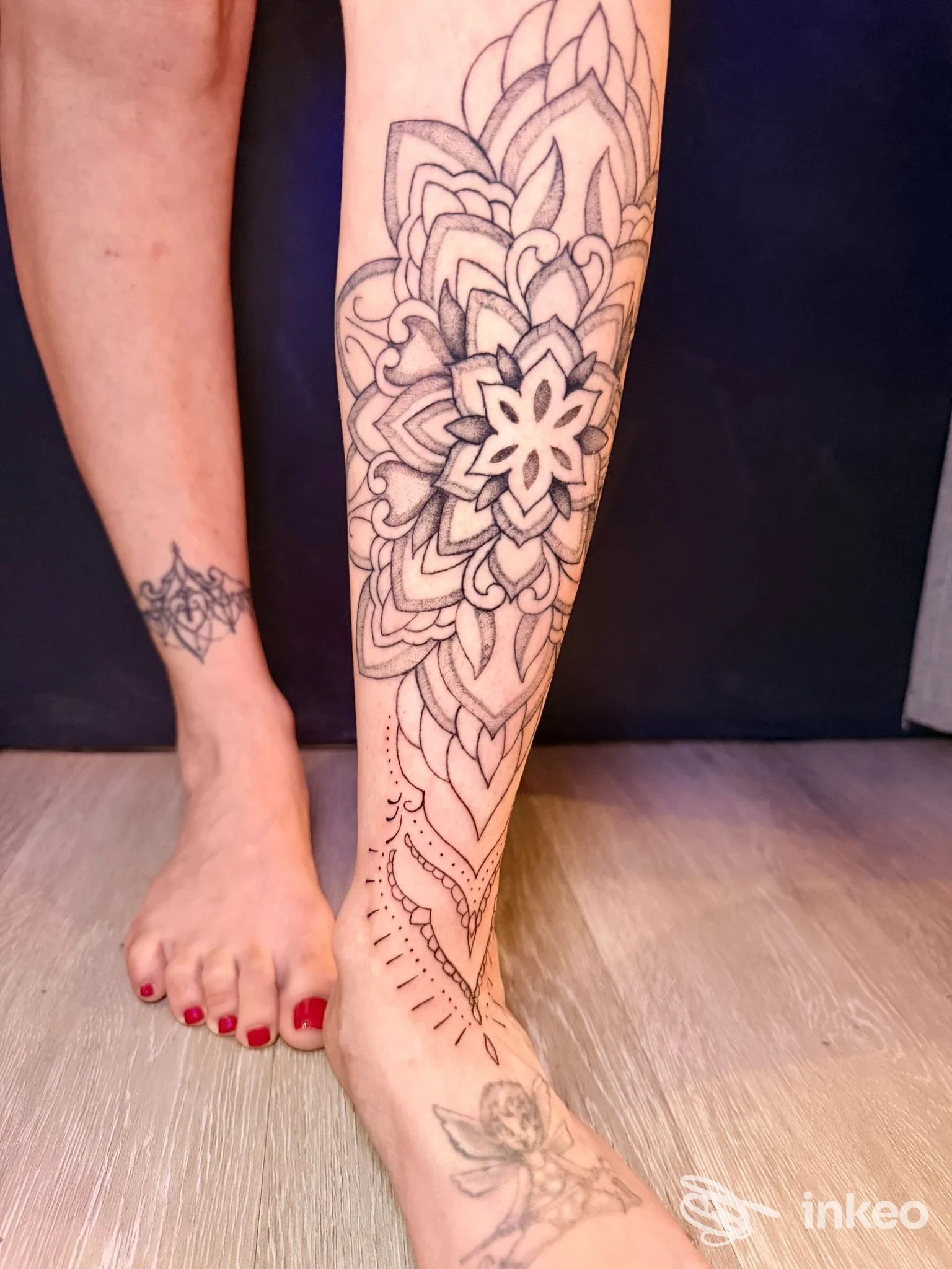 Grande tatuaggio mandala floreale sulla gamba di una persona, visibile dalla caviglia al ginocchio, senza overlay: studio Curly Ink Tattoo Shop a Rimini.