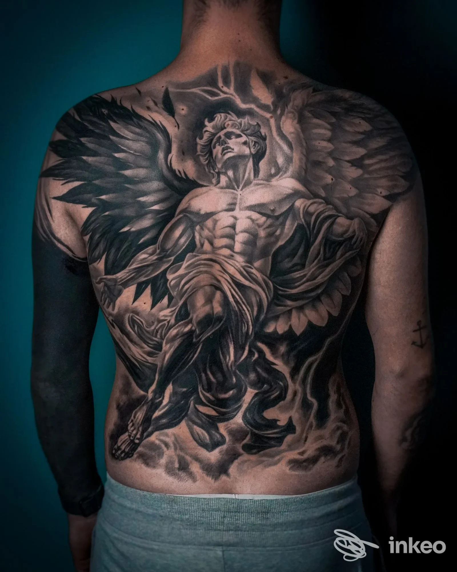 Tattoo sul dorso di un uomo raffigurante un angelo alato, in bianco e nero, che copre quasi tutta la schiena; Lighthouse Tattoo e Piercing, Reggio nell'Emilia.