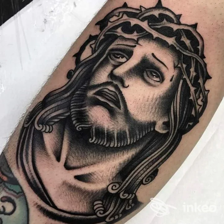 Tattoo in grayscale raffigurante un volto con corona di spine sul braccio, realizzazione su pelle umana presso lo studio Neko Tattoo a Castelfranco Emilia.