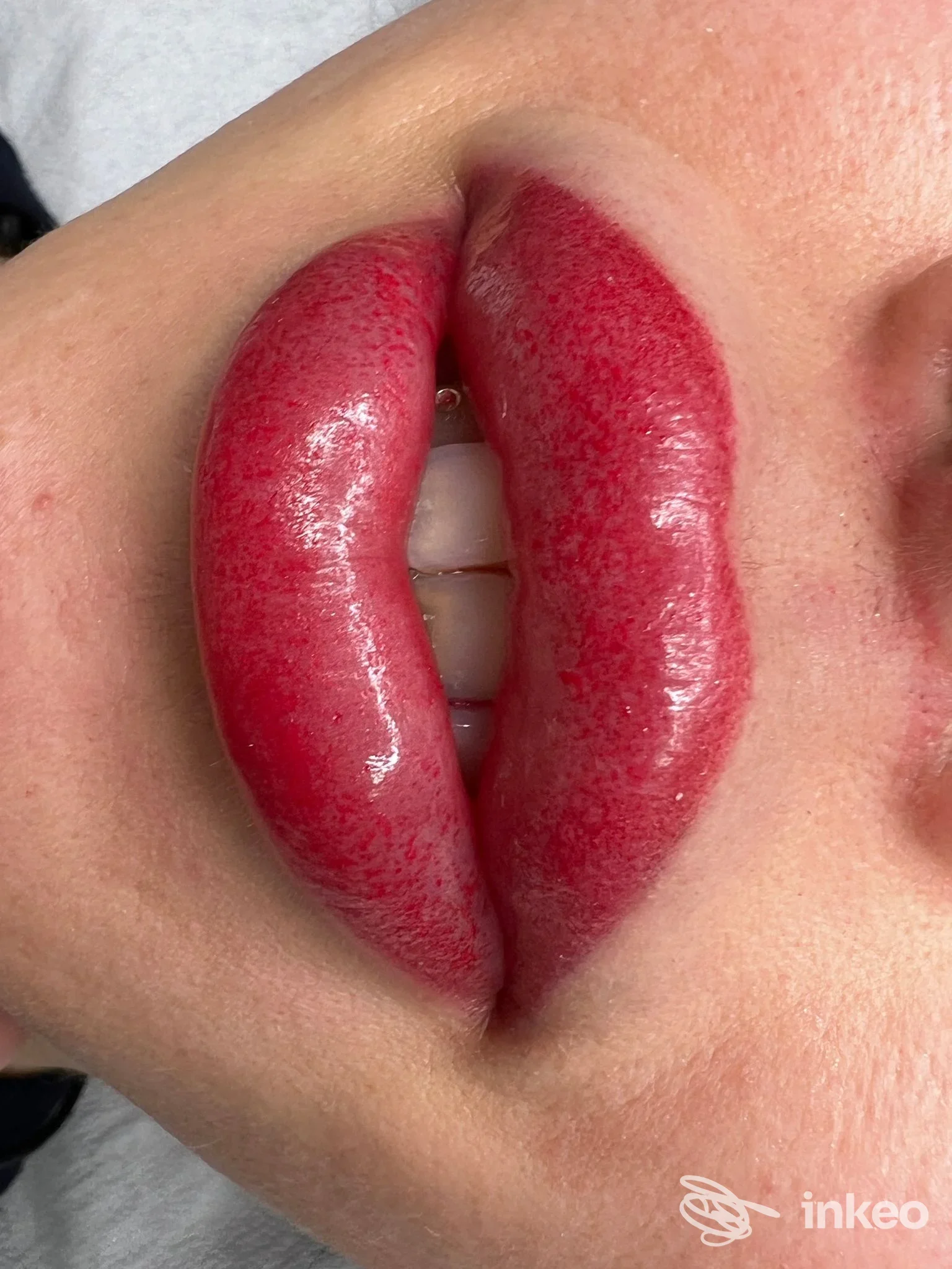 Labbra di una persona con trucco permanente rosso-rosato, primo piano su labbra lucide, senza viso intero visibile; studio Beauty Room Permanent Make Up, Ravenna.