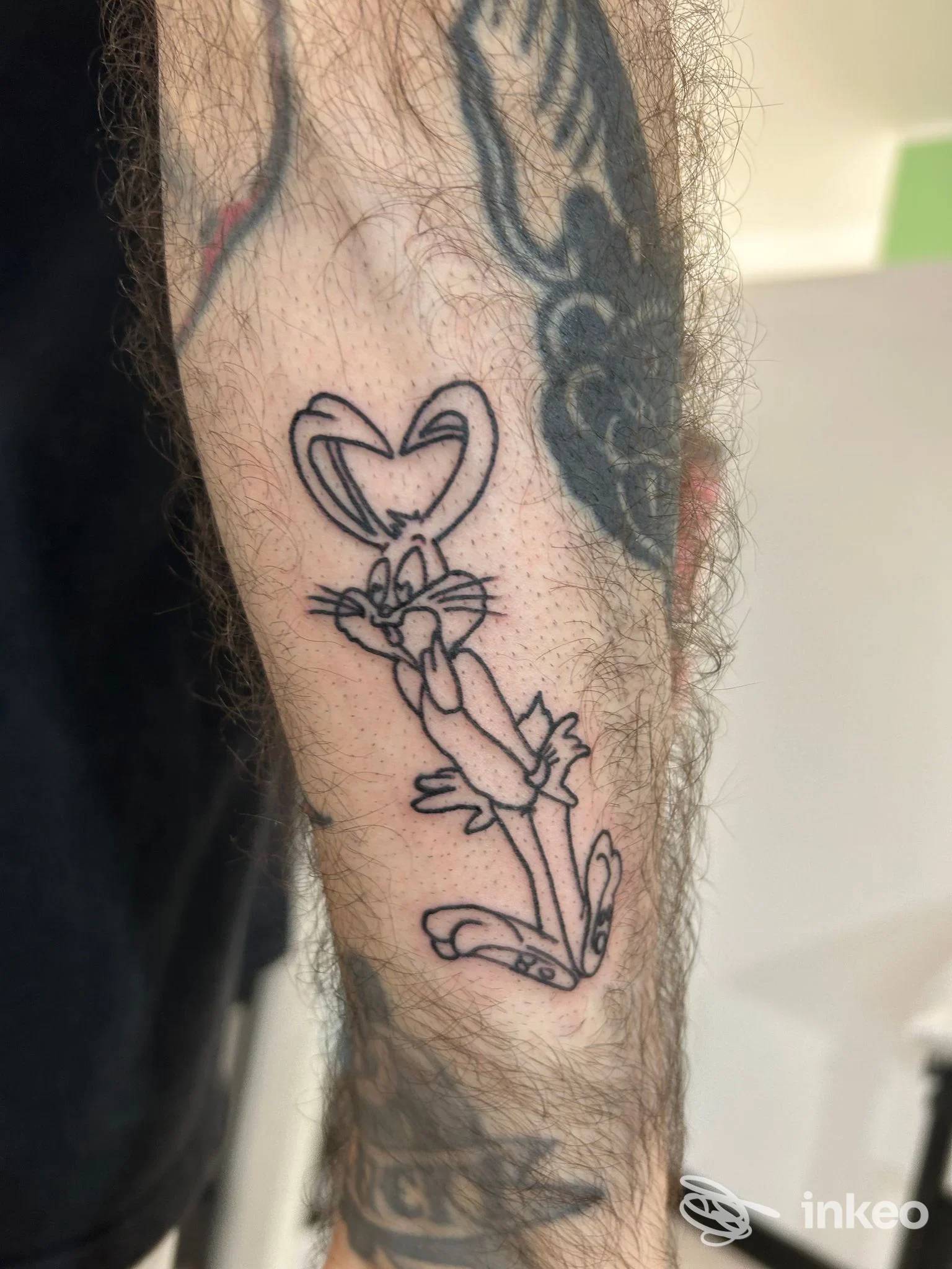 Tatuaggio in stile line art su avambraccio sinistro raffigurante un coniglio/cartone, disegno nero su pelle, realizzato dallo studio Modern Ink Tattoo a Misano Adriatico.