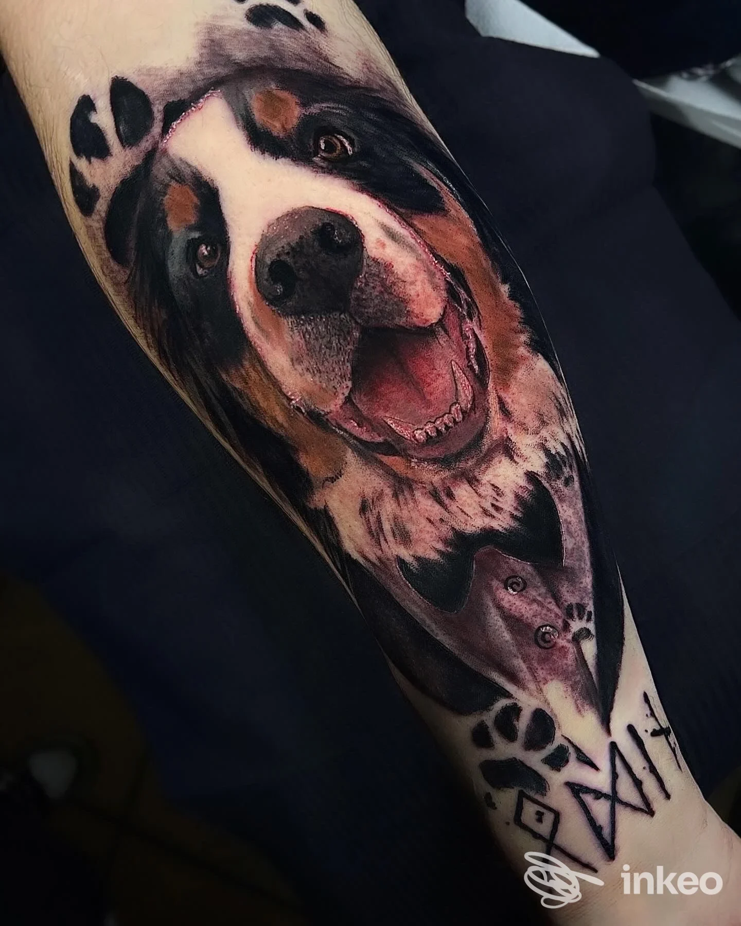 Tattoo realistico su avambraccio raffigurante un cane sorridente, con dettagli di pelo e incarnato, realizzato sulla pelle.