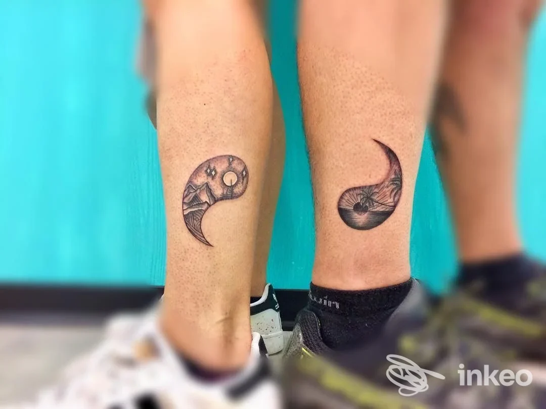 Due polpacci mostrano tatuaggi a forma di luna crescente in bianco e nero, sfondo blu, nessun volto visibile; Parma, Old Roger Tattoo Studio.