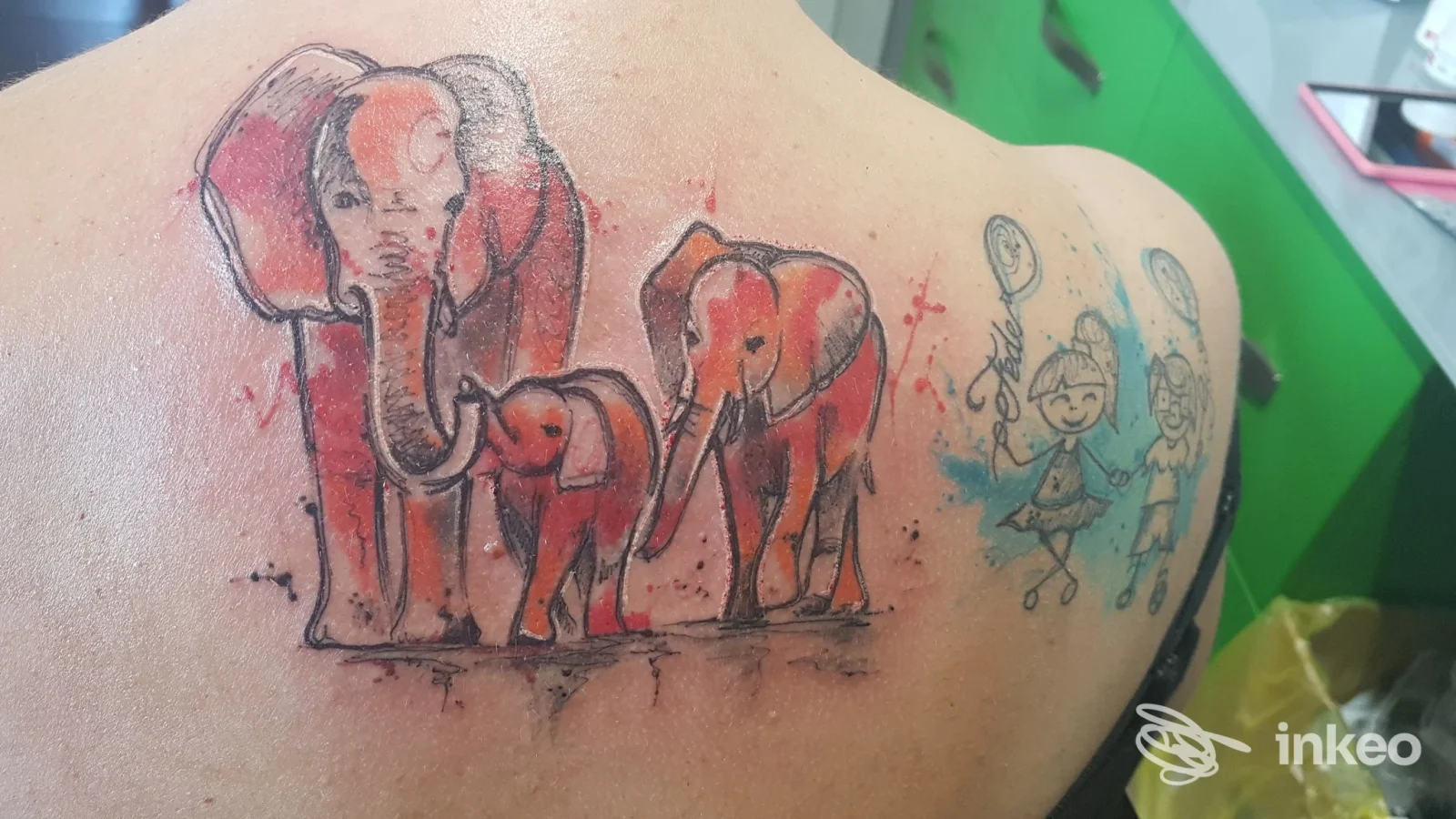 Tatuaggio di elefanti colorati sulla schiena di una persona, visibile chiaramente, senza overlay o testo.